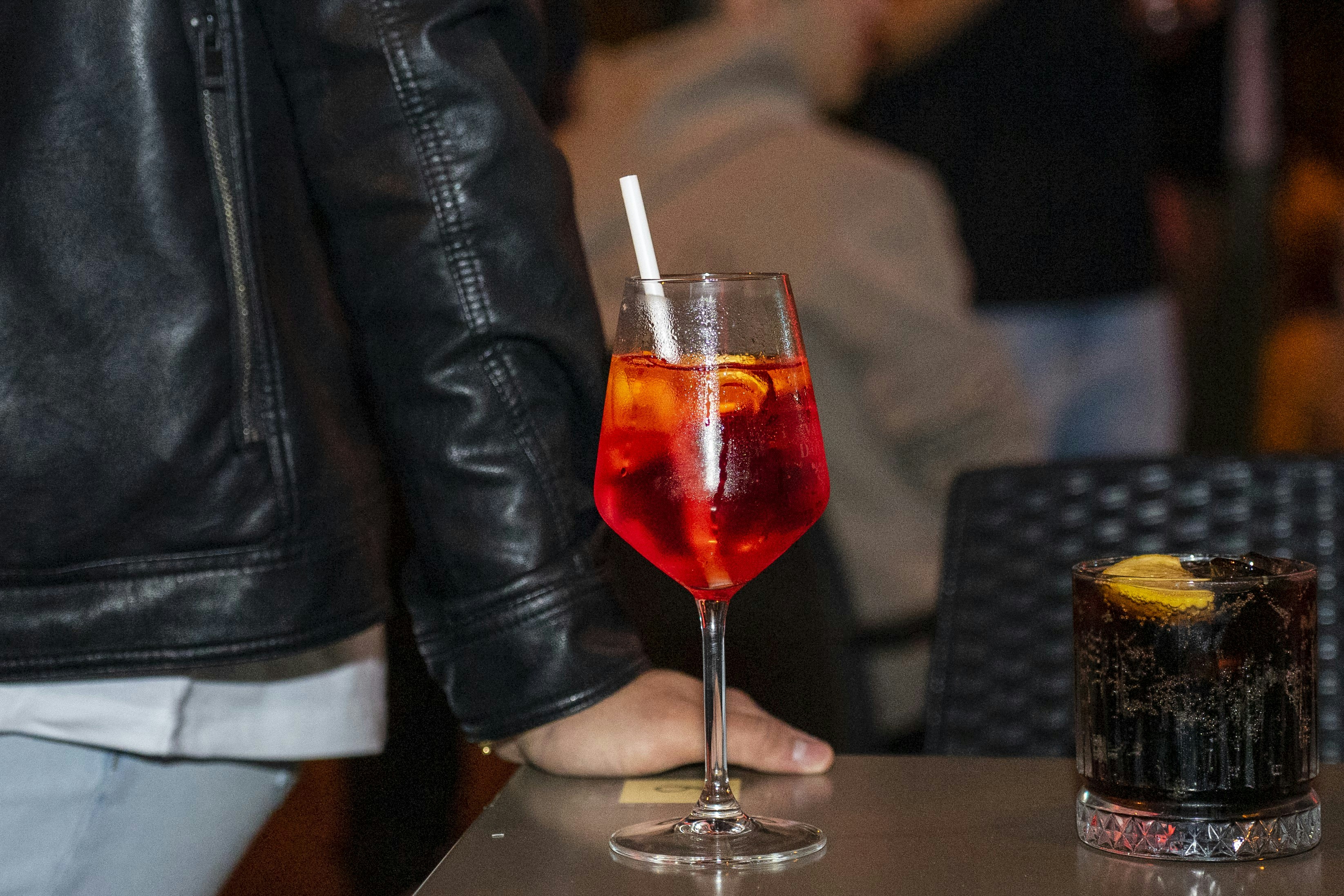 A close up of a person sitting at a table with a drink
