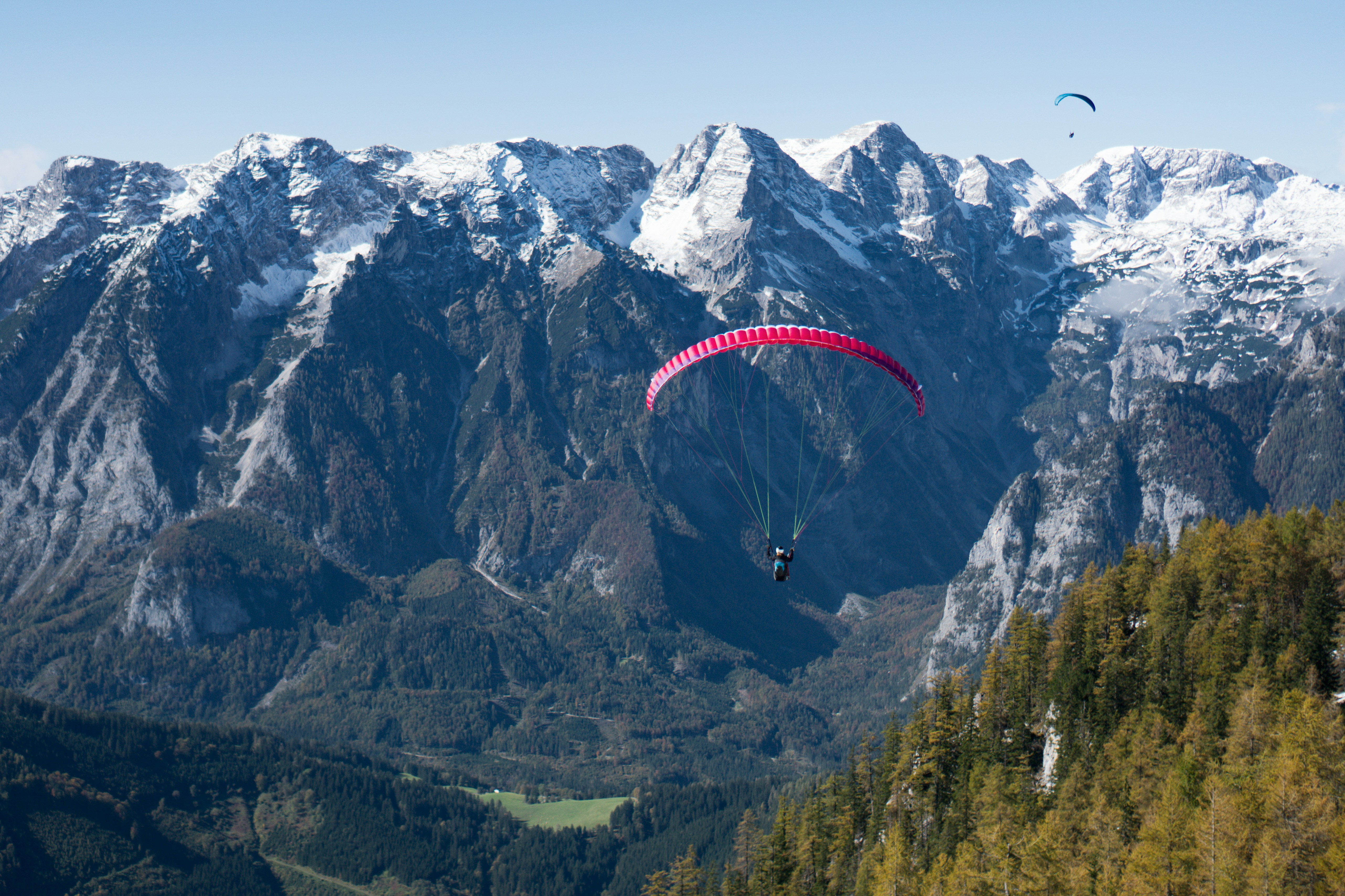 A paraglider is flying over a mountain range