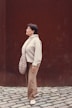 A woman standing in front of a brown wall