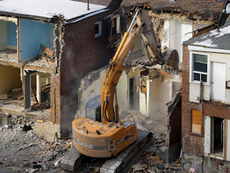 A bulldozer digging through the rubble of a building