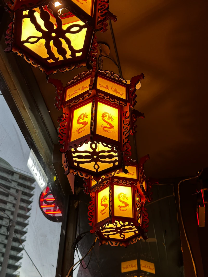 Glowing red lanterns hanging under a dark ceiling