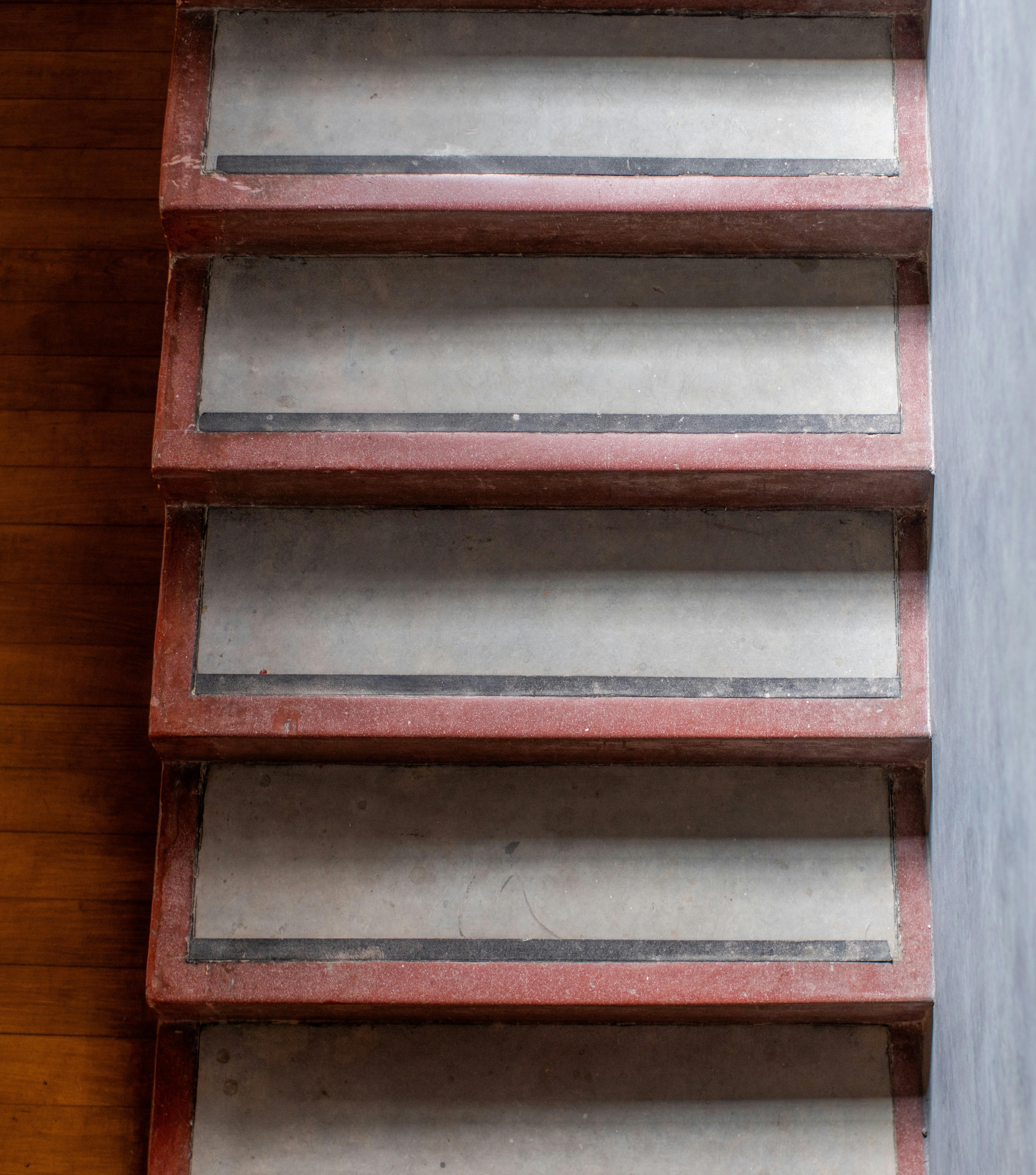 A red shelf sitting on top of a wooden floor