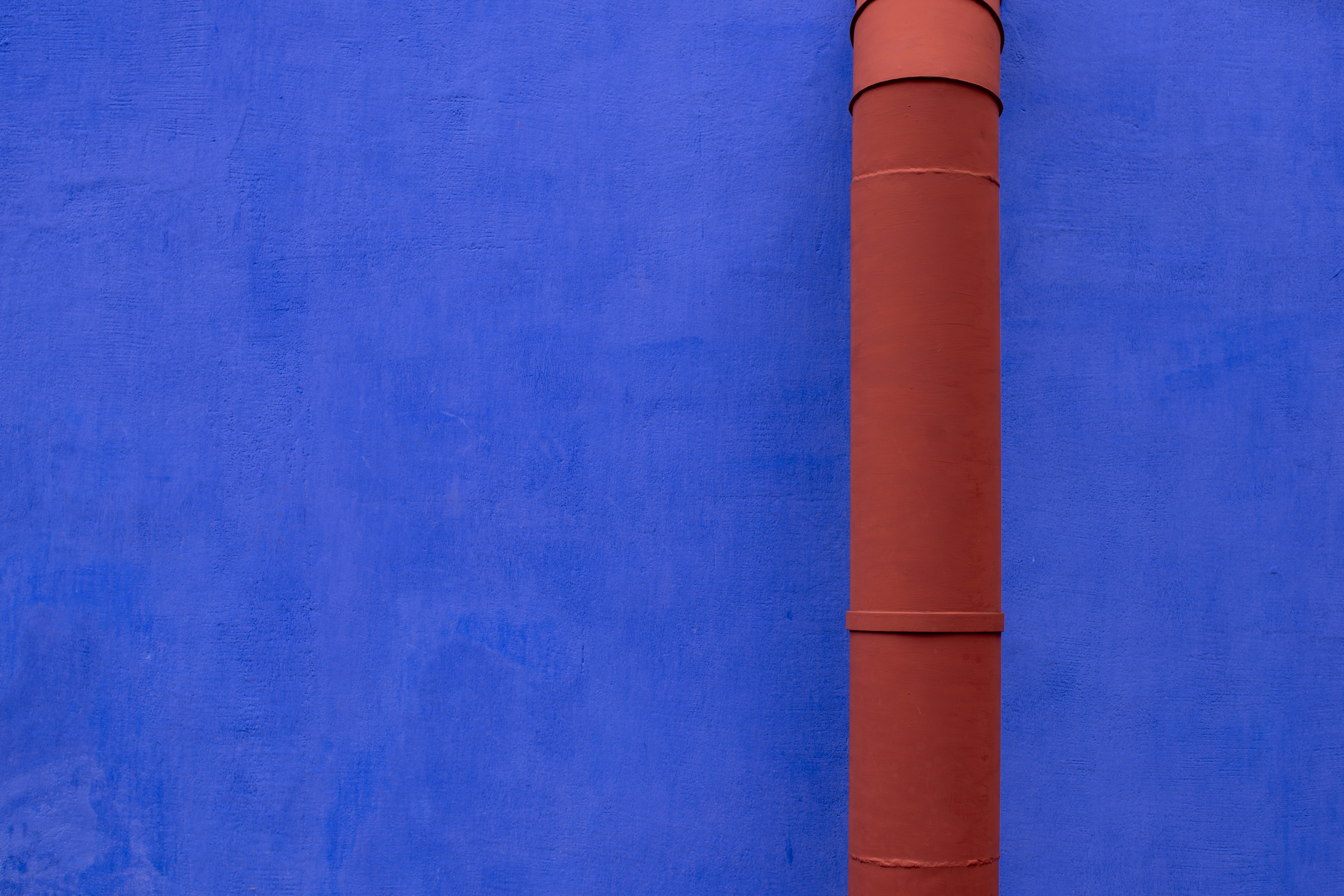 A blue wall with a red pipe on it