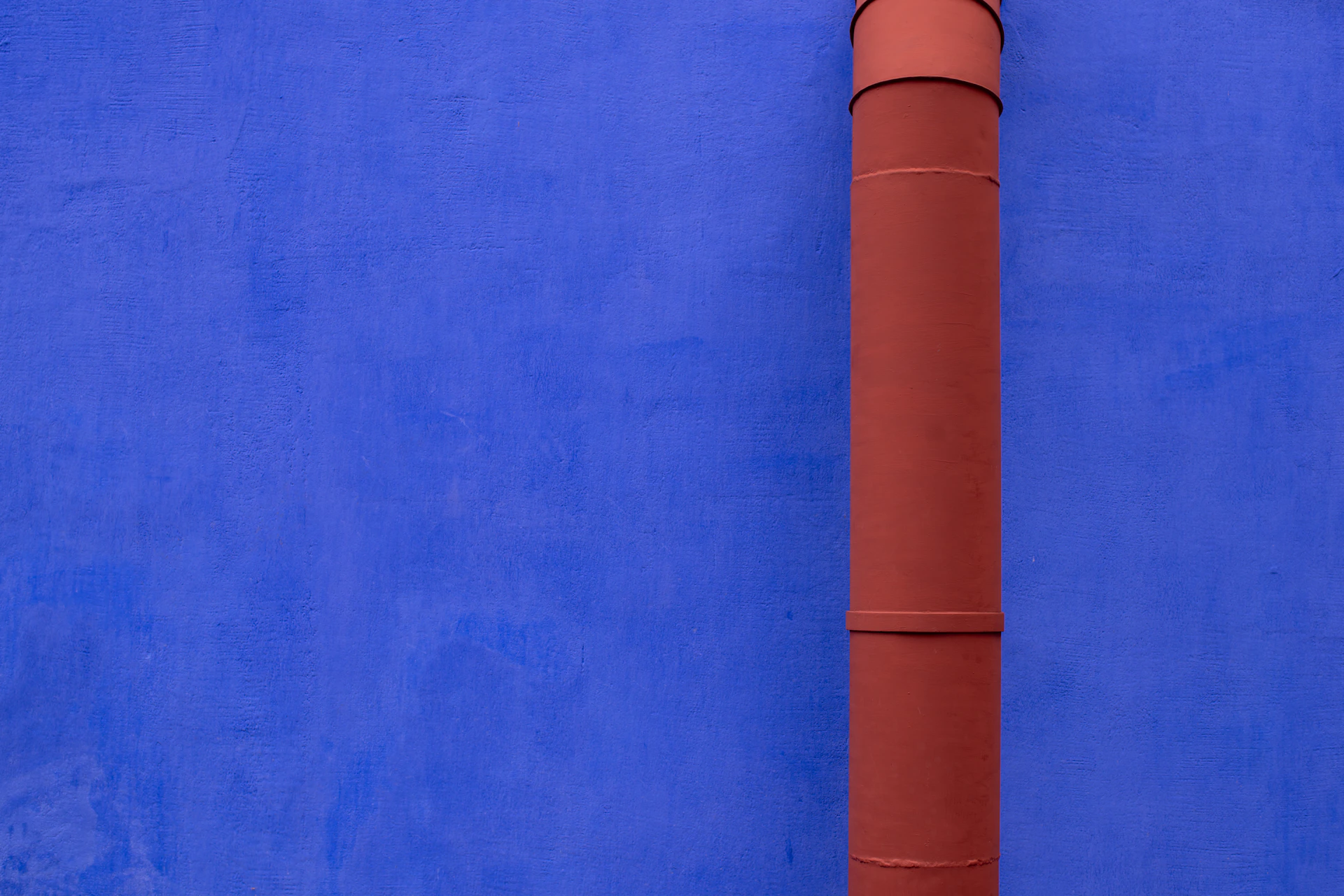 A blue wall with a red pipe on it