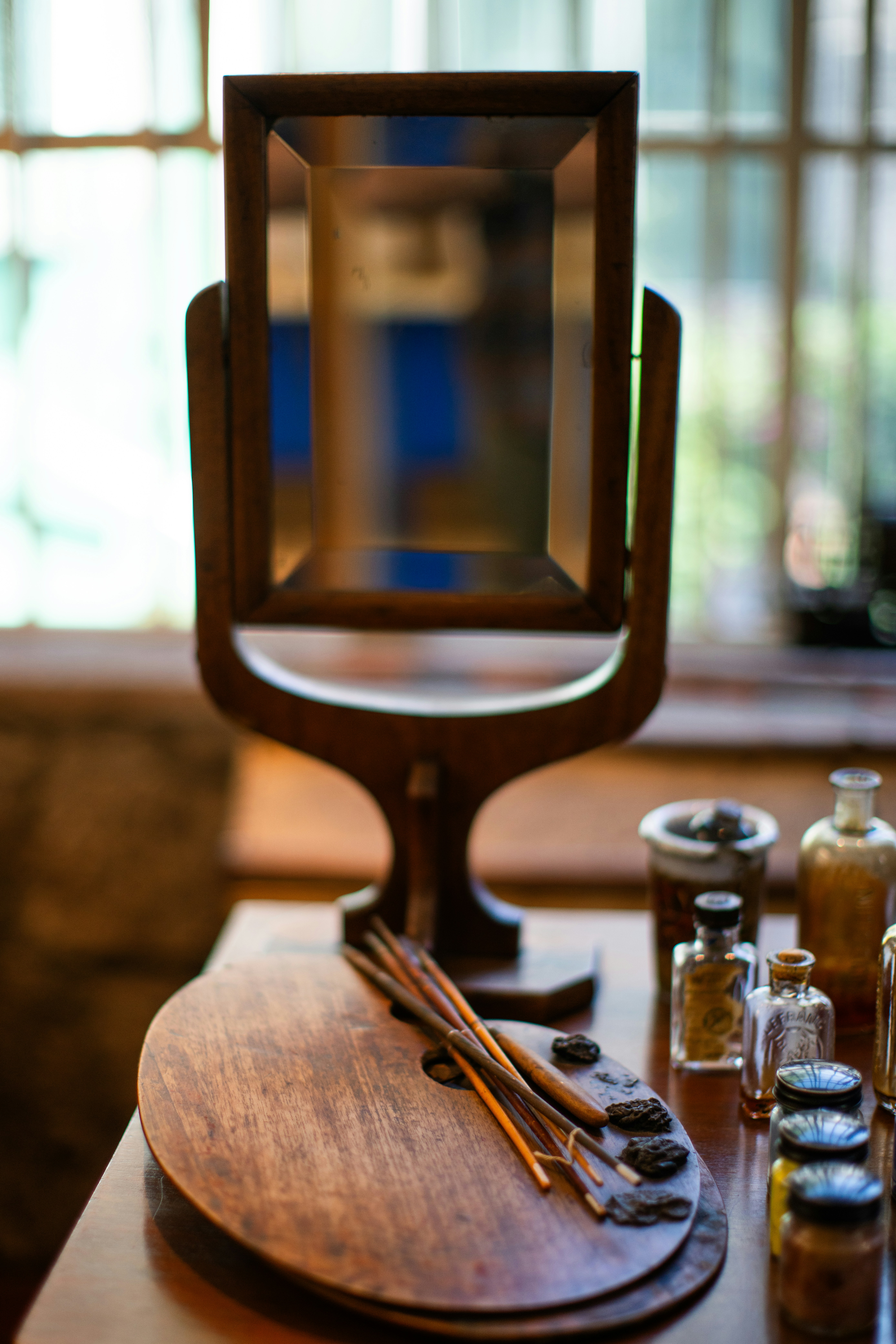 A wooden table topped with bottles and a mirror