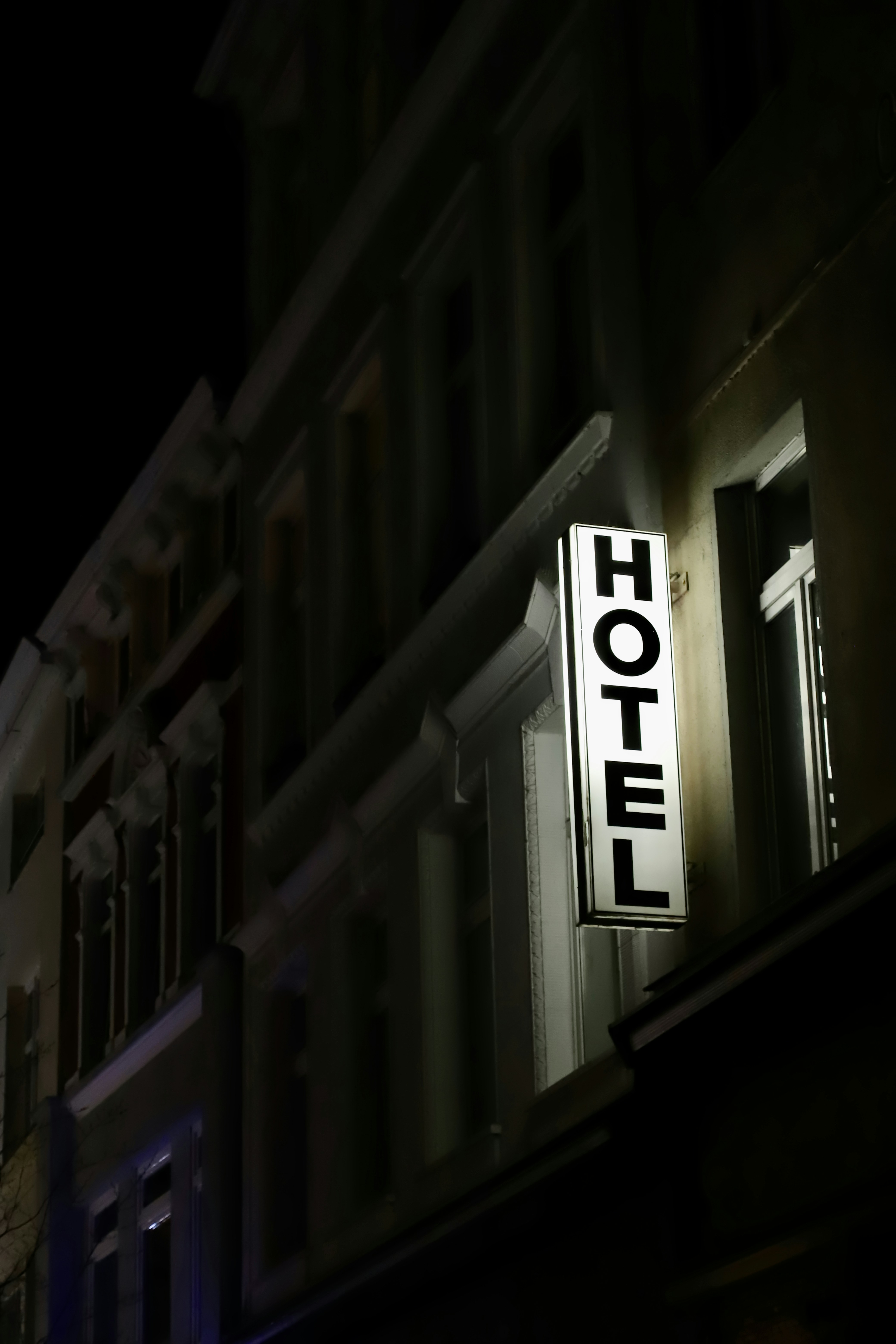 A hotel sign lit up at night on the side of a building