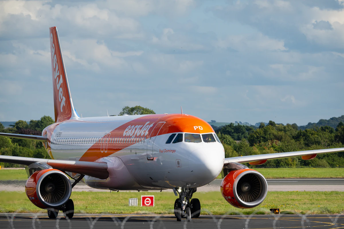 An orange and white airliner on an airport runway