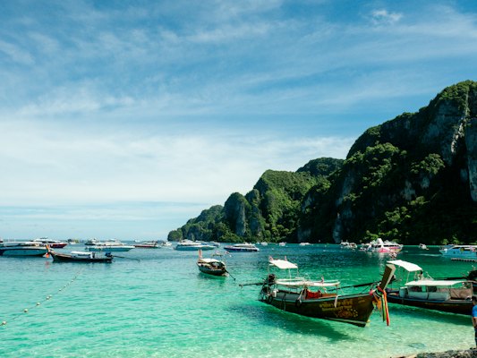 A group of boats floating on top of a body of water — Koh Lanta, Thailand