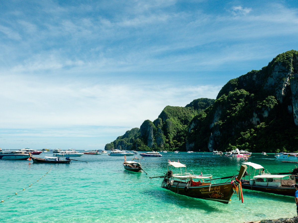 Longtail boats anchored in turquoise waters off the Thai coast