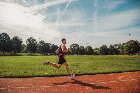A man running across a field on a sunny day