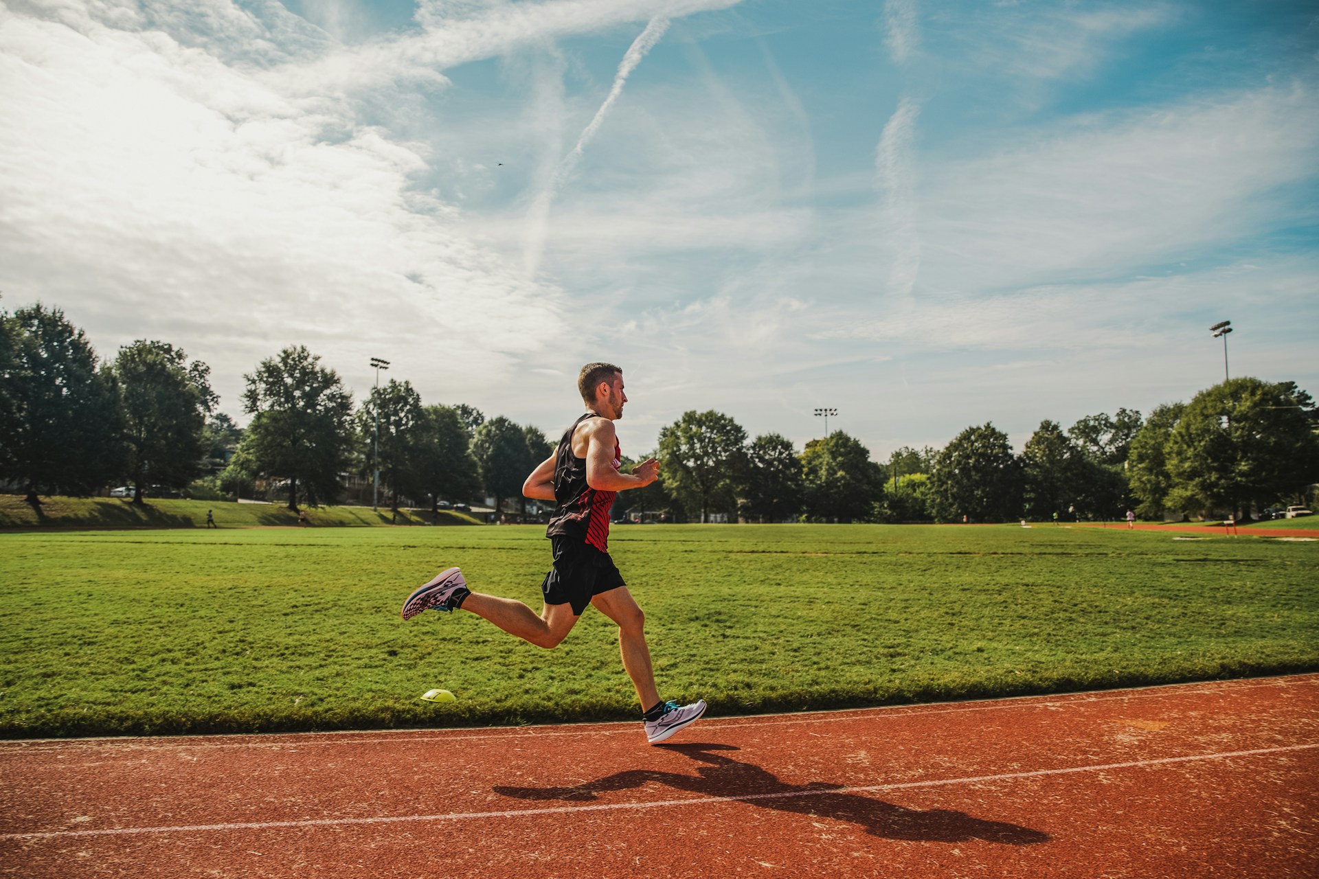 A man running across a field on a sunny day