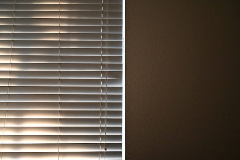 Fenster mit Jalousien vor hellem Himmel