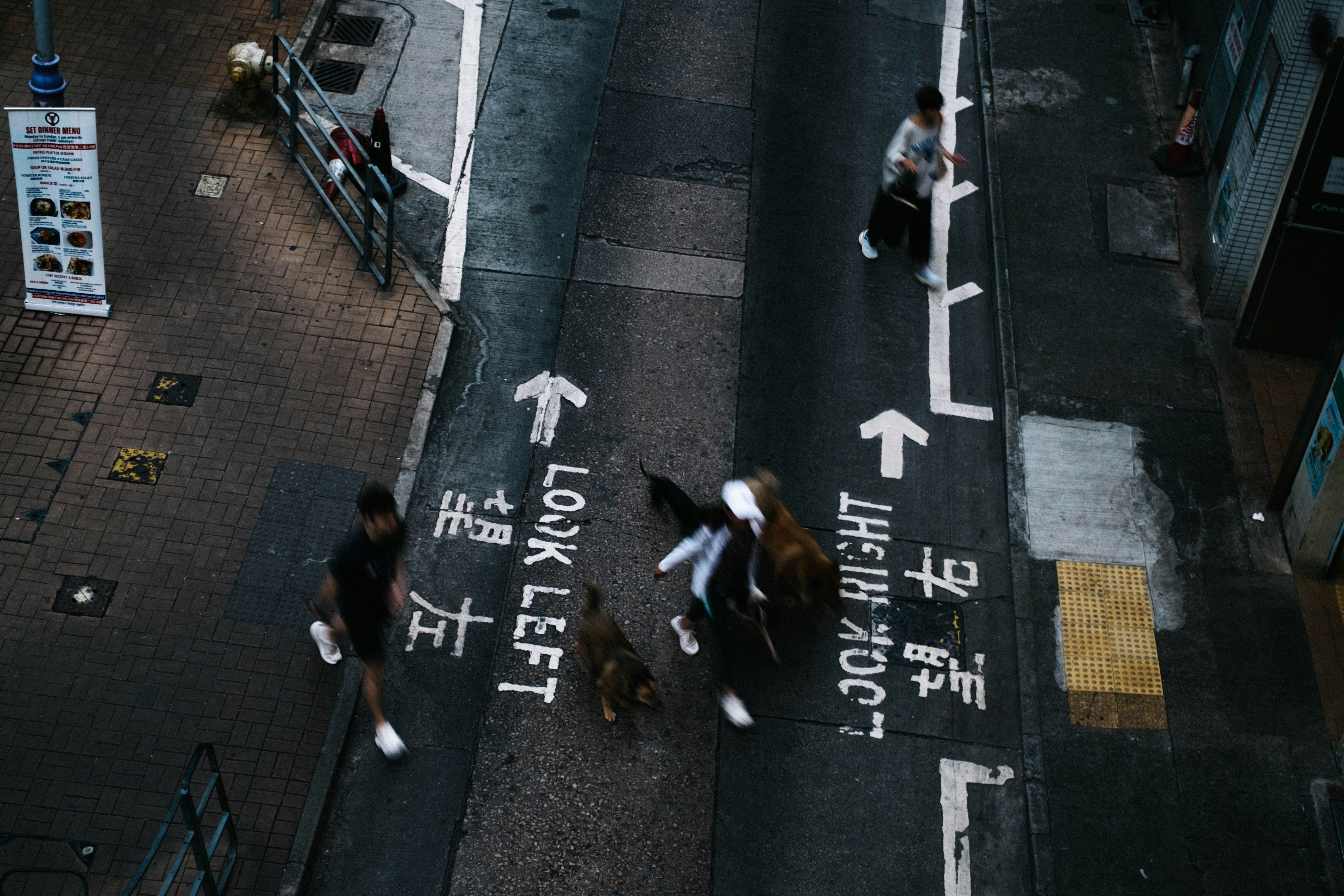 A group of people walking across a street