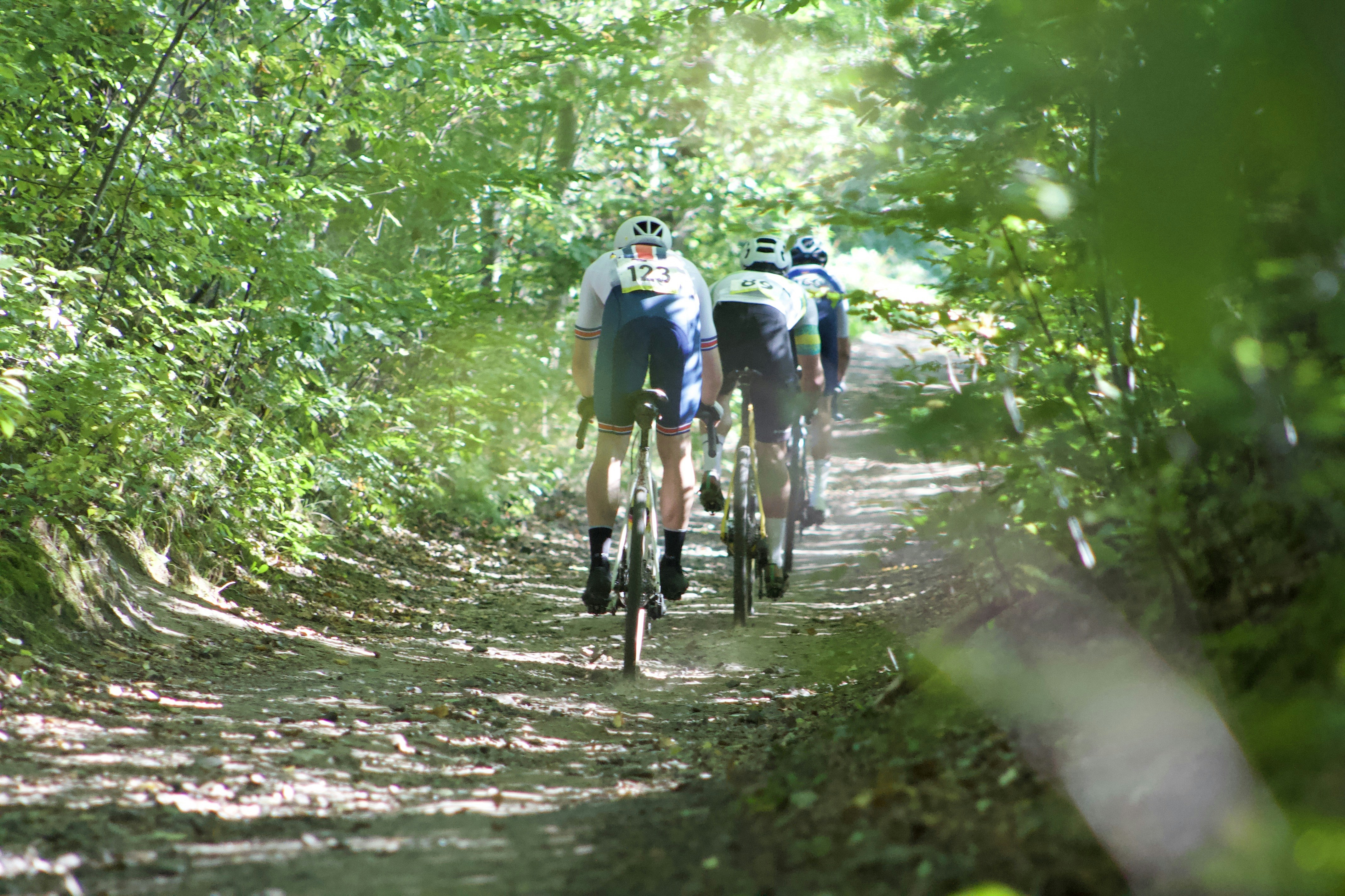A group of people riding bikes down a dirt road