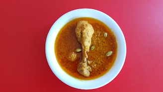 A bowl of soup on a red table