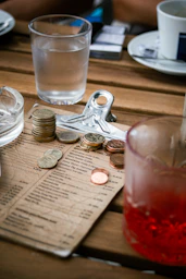 A wooden table topped with lots of coins