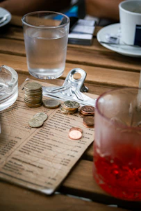 A wooden table topped with lots of coins