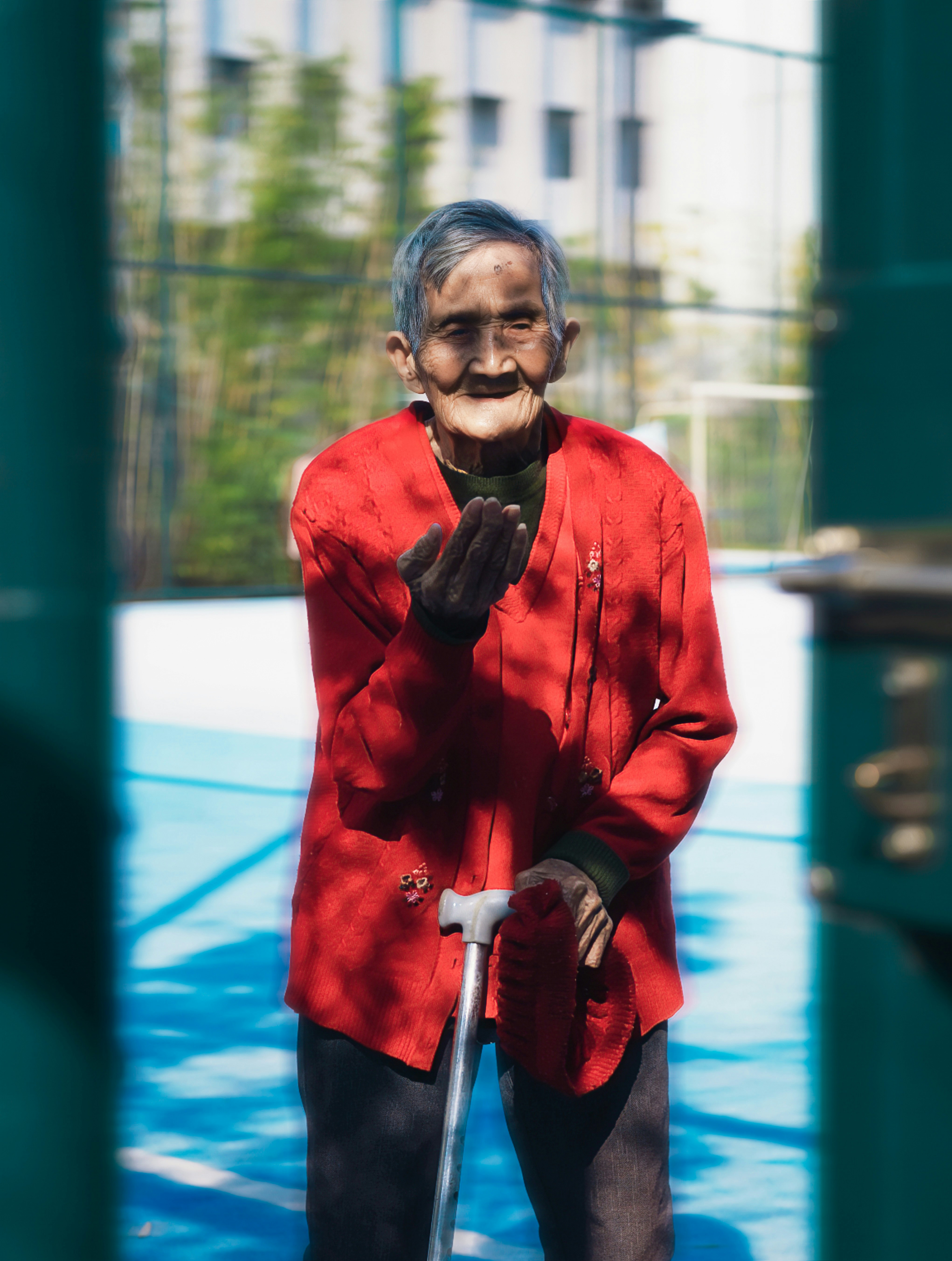 A man in a red jacket is holding a cane