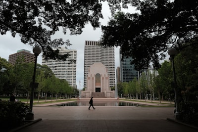 A person walking in front of a tall building