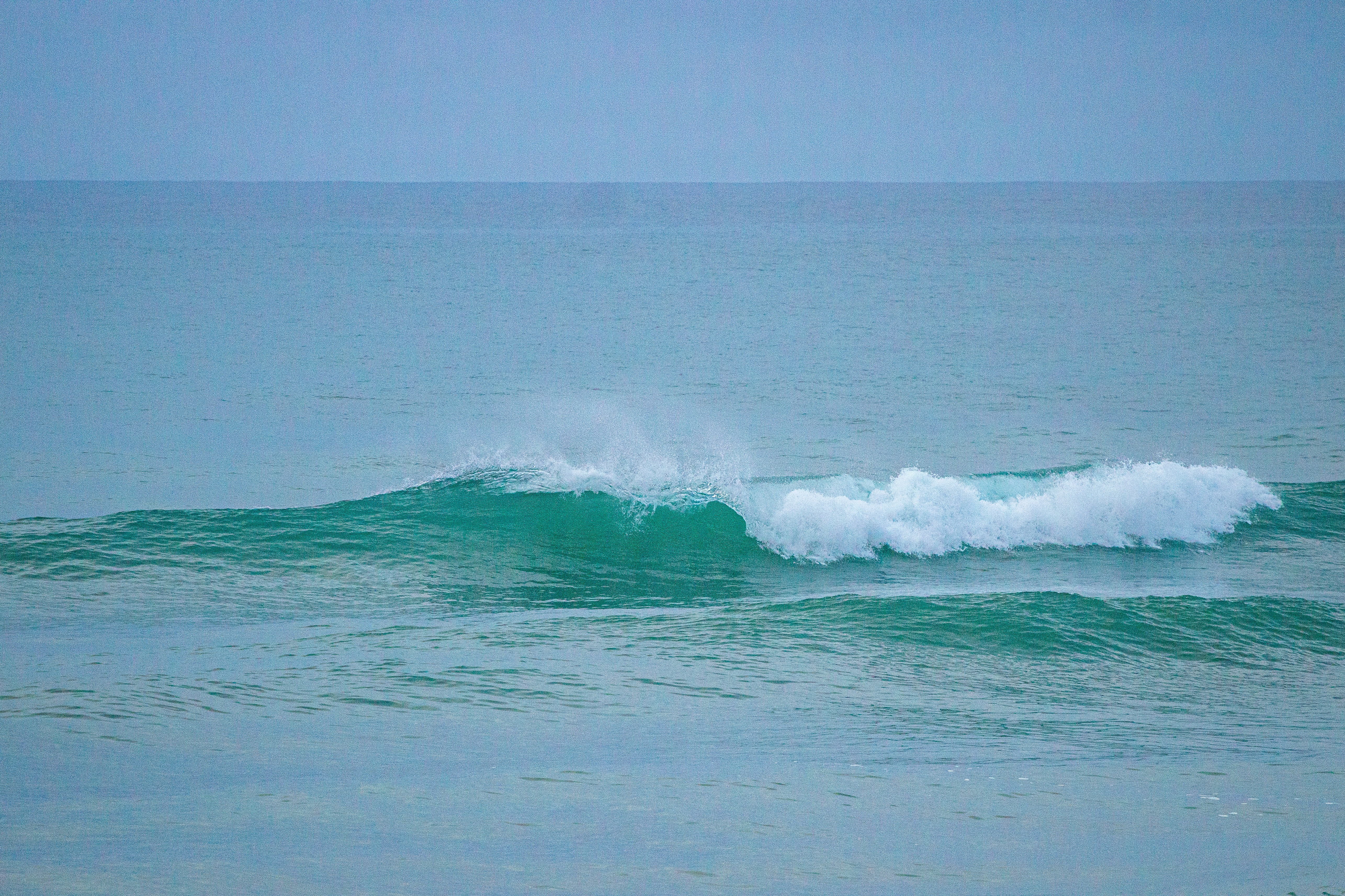 A person riding a surfboard on a wave in the ocean