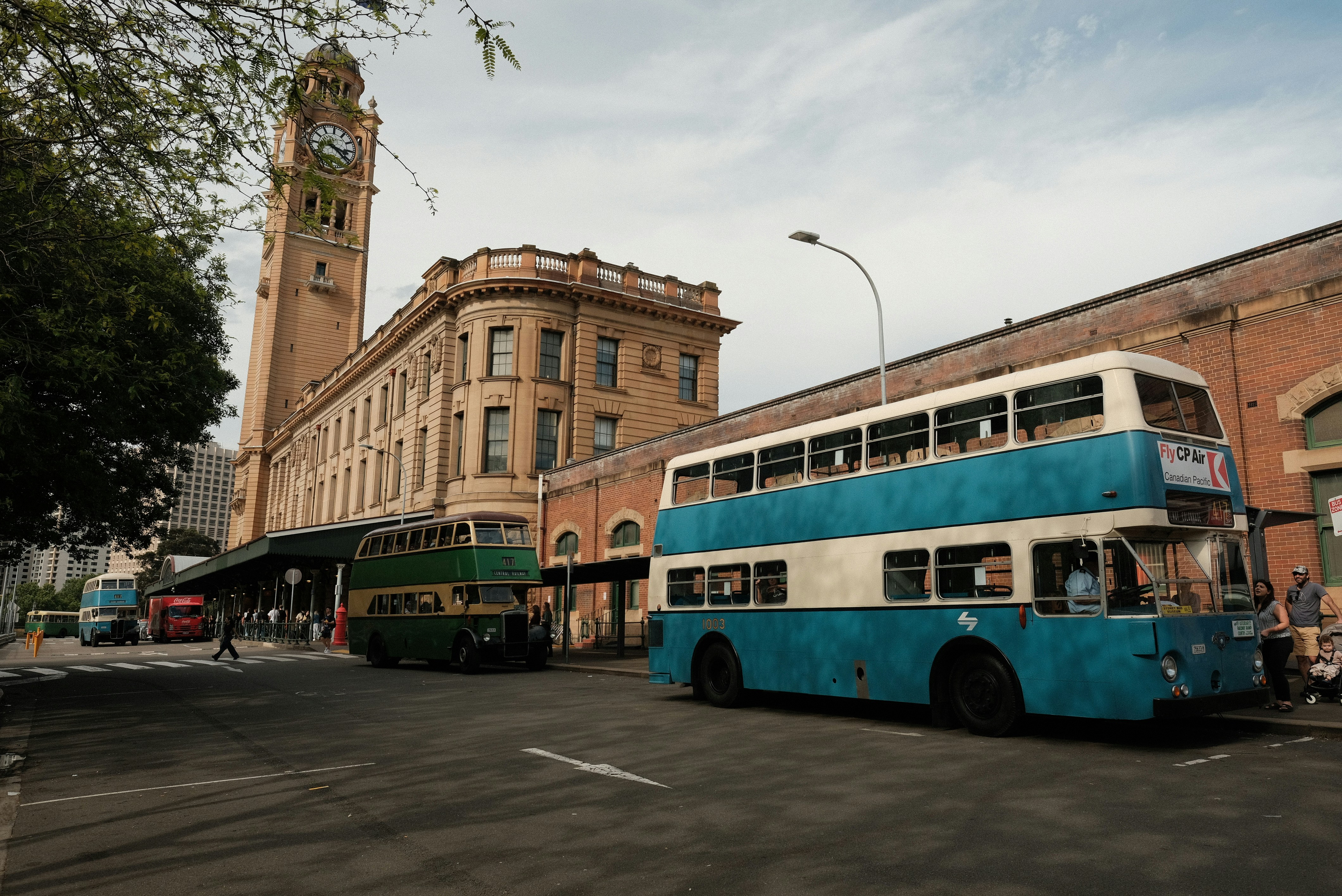 A blue and white double decker bus parked in front of a building