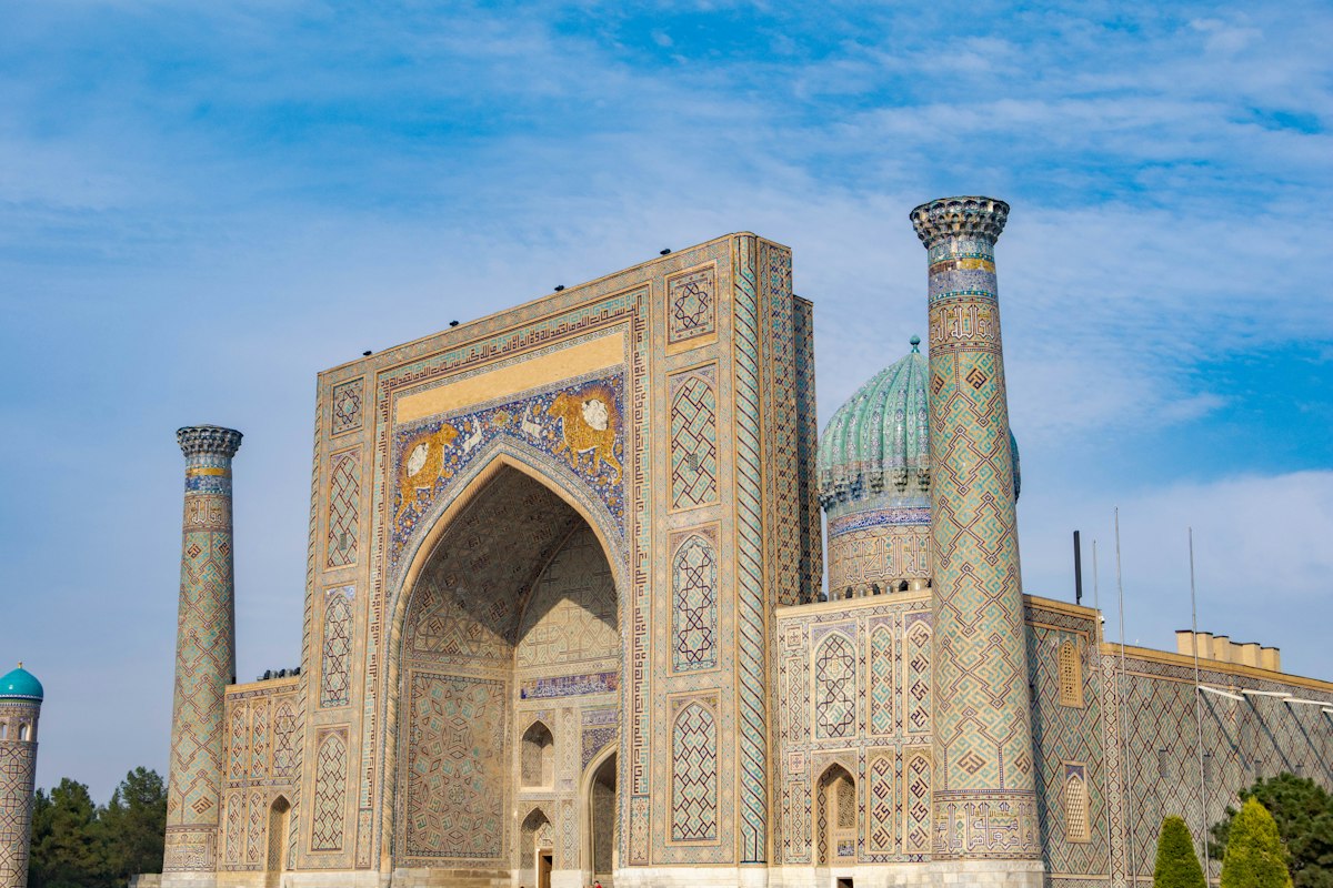 سردر کاشی‌کاری و گنبد فیروزه‌ای مدرسه‌ی شیردار در میدان ریگستان سمرقند