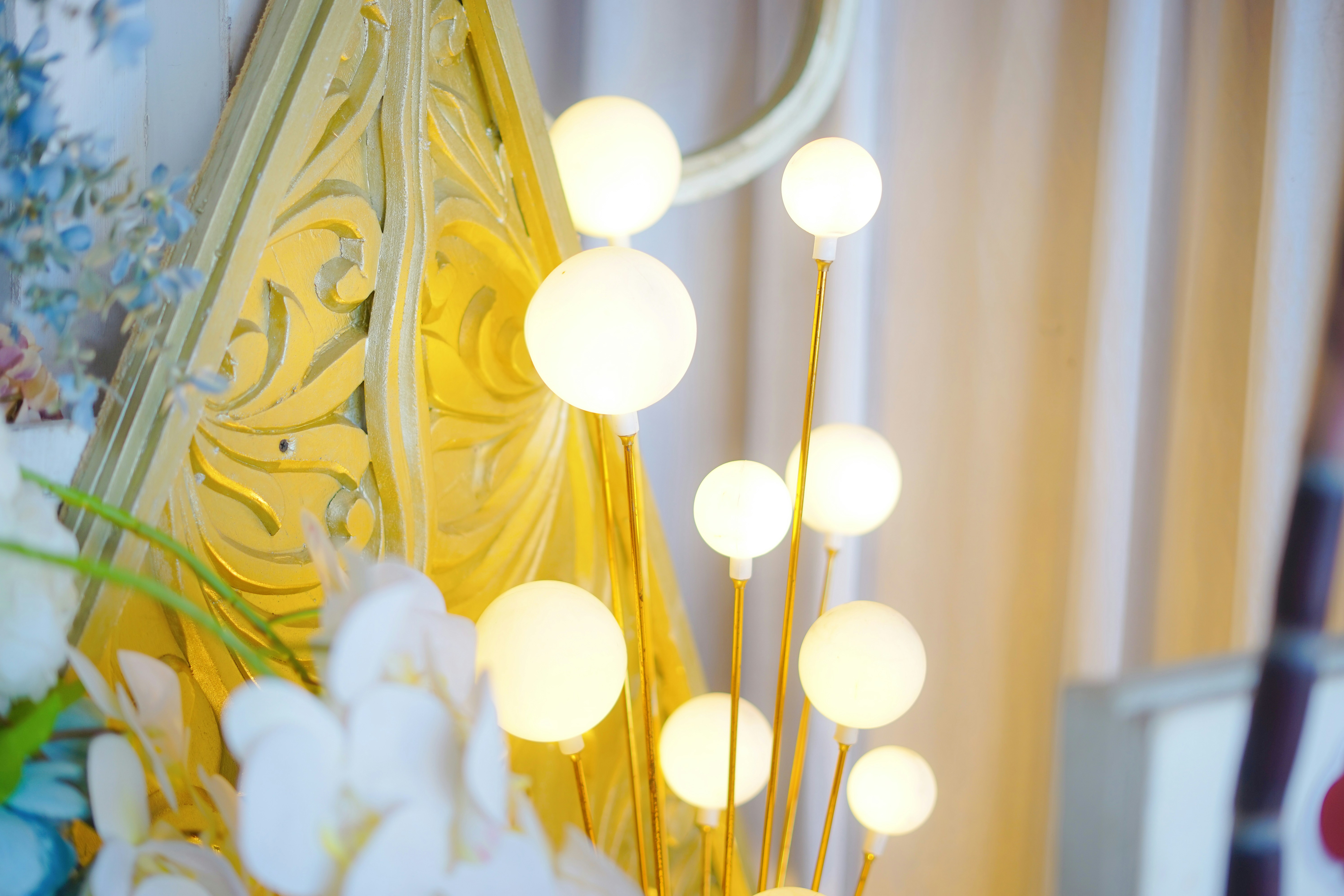 A vase filled with white flowers next to a mirror