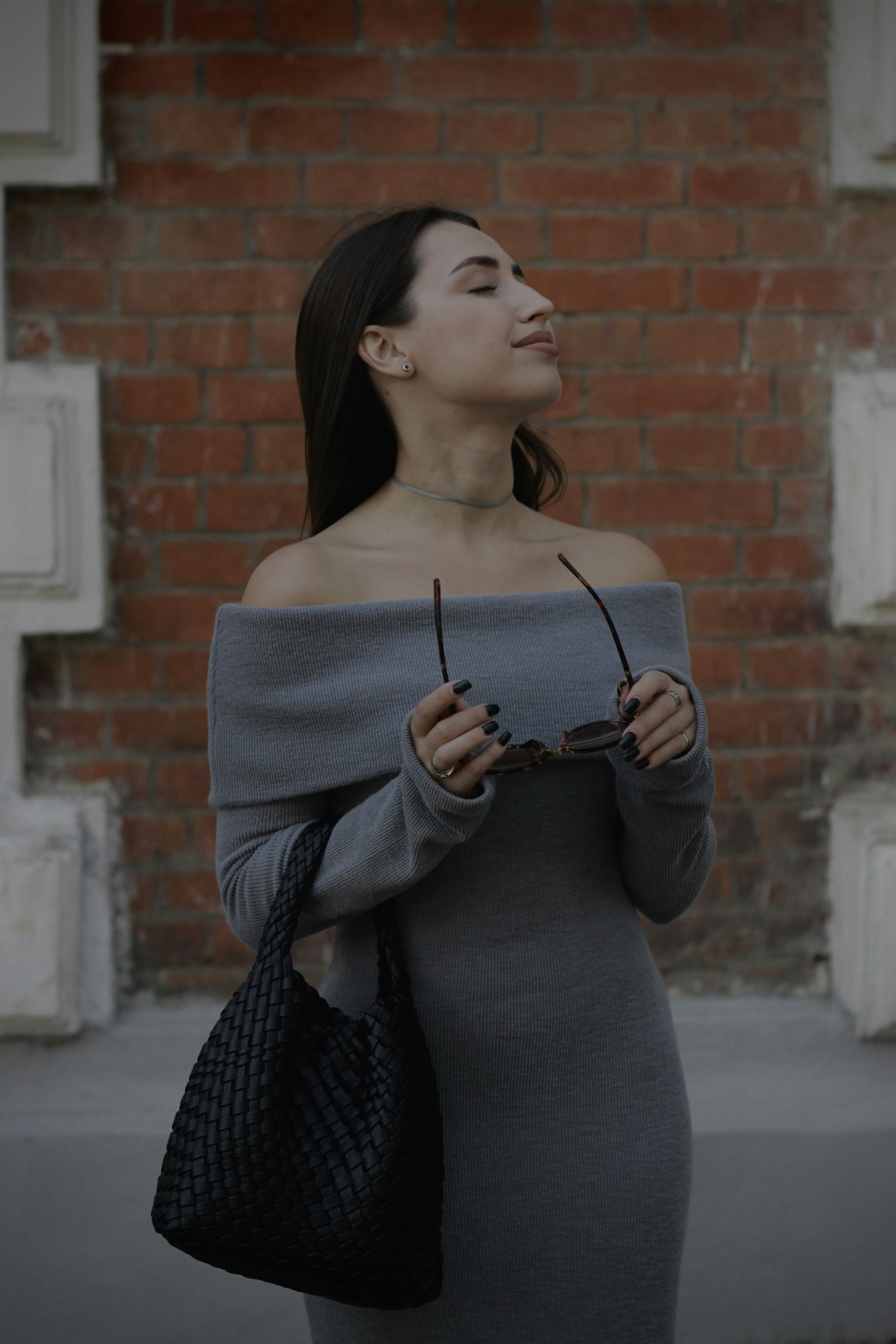 A woman standing in front of a brick wall