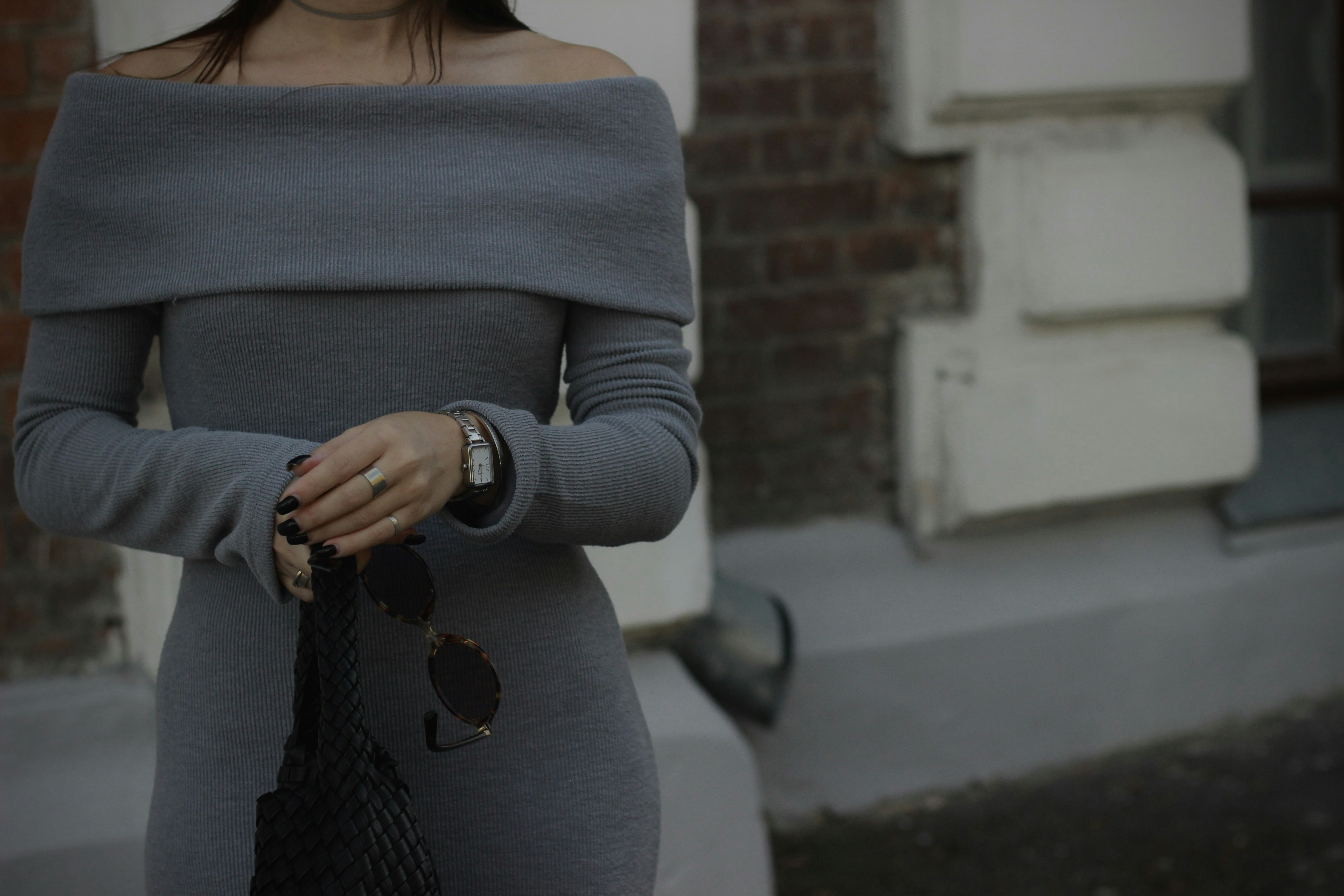A woman in a grey dress walking down the street