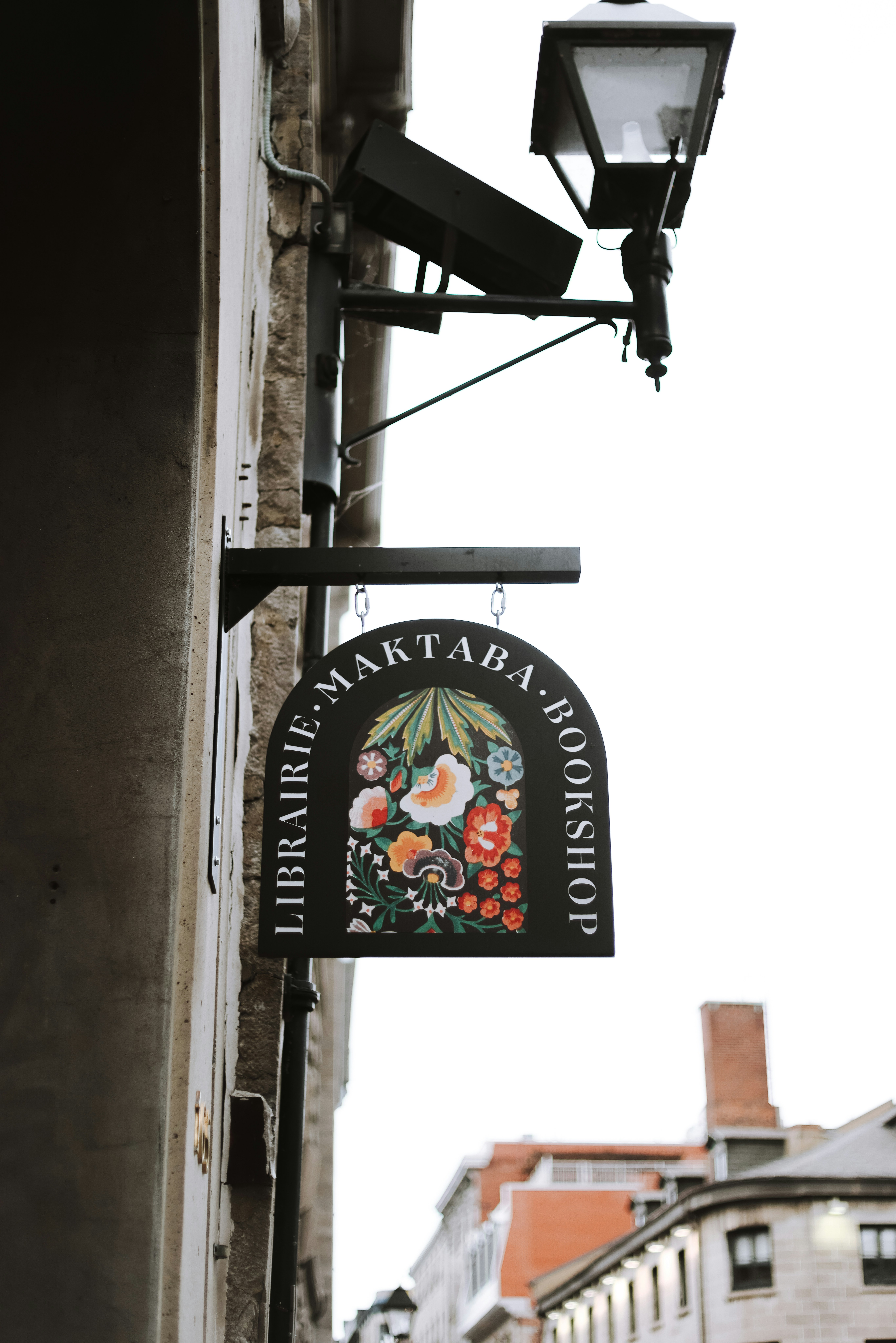 A sign hanging from the side of a building