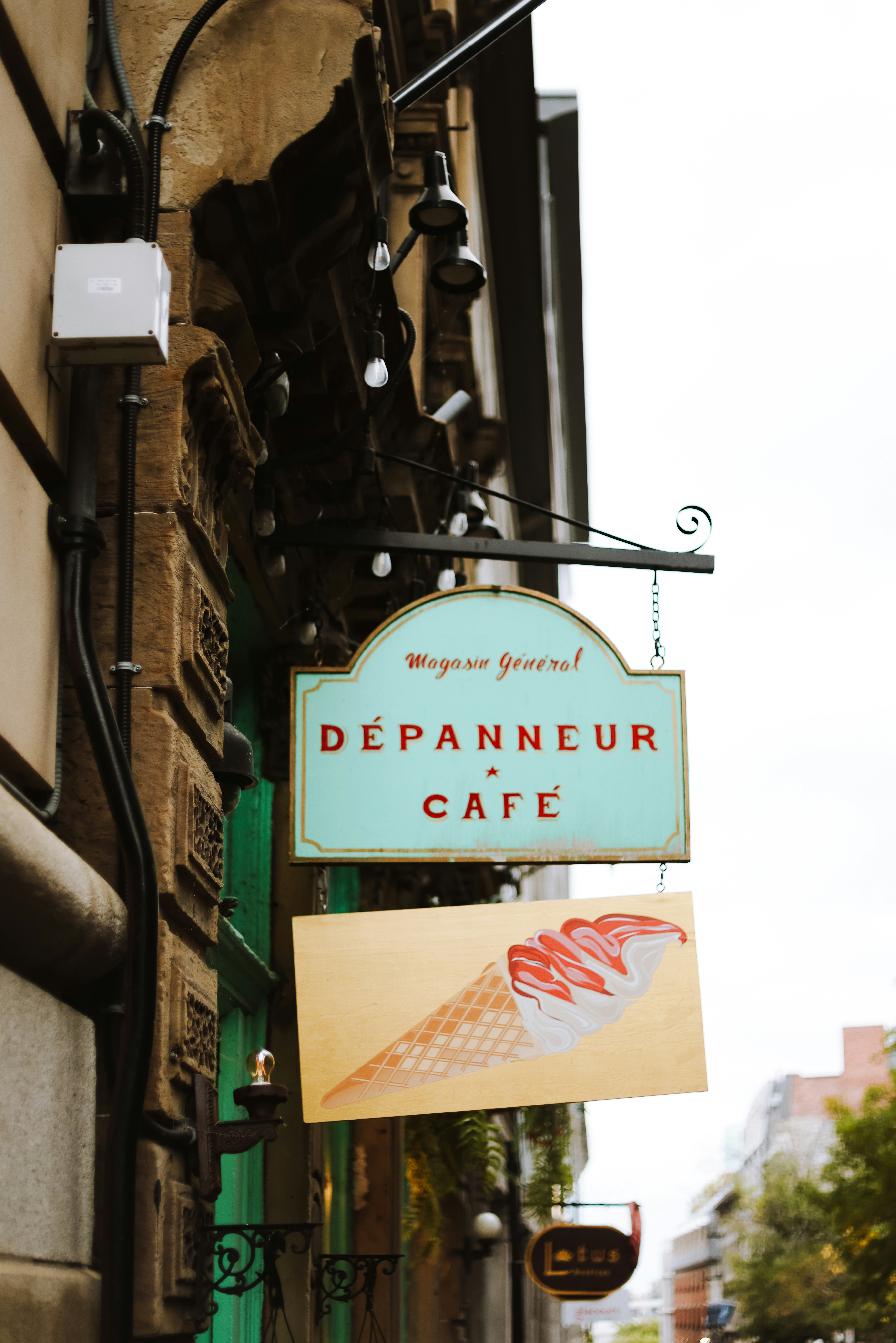 A sign hanging from the side of a building