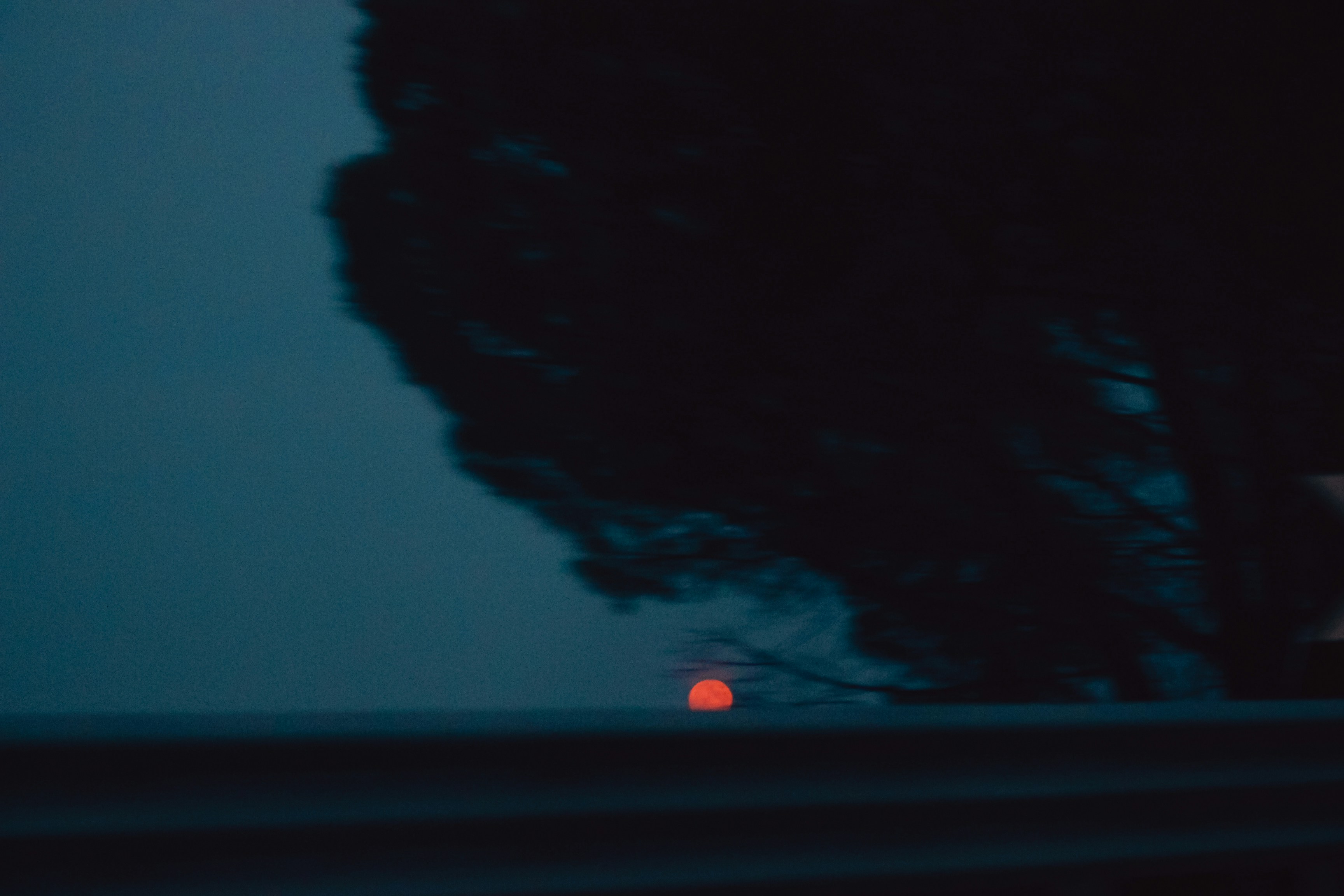 A blurry photo of a street light and a tree