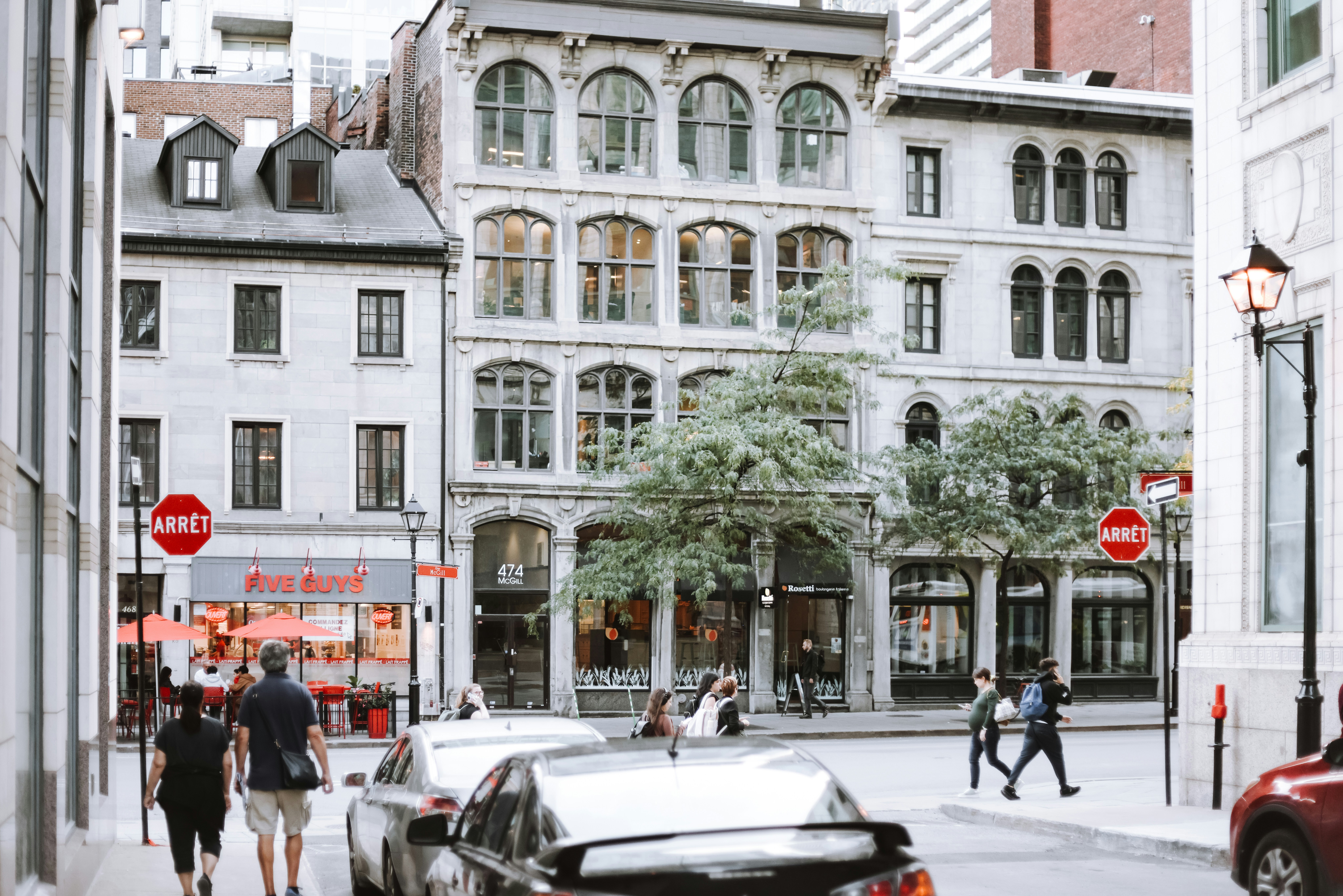 A group of people walking down a street next to tall buildings