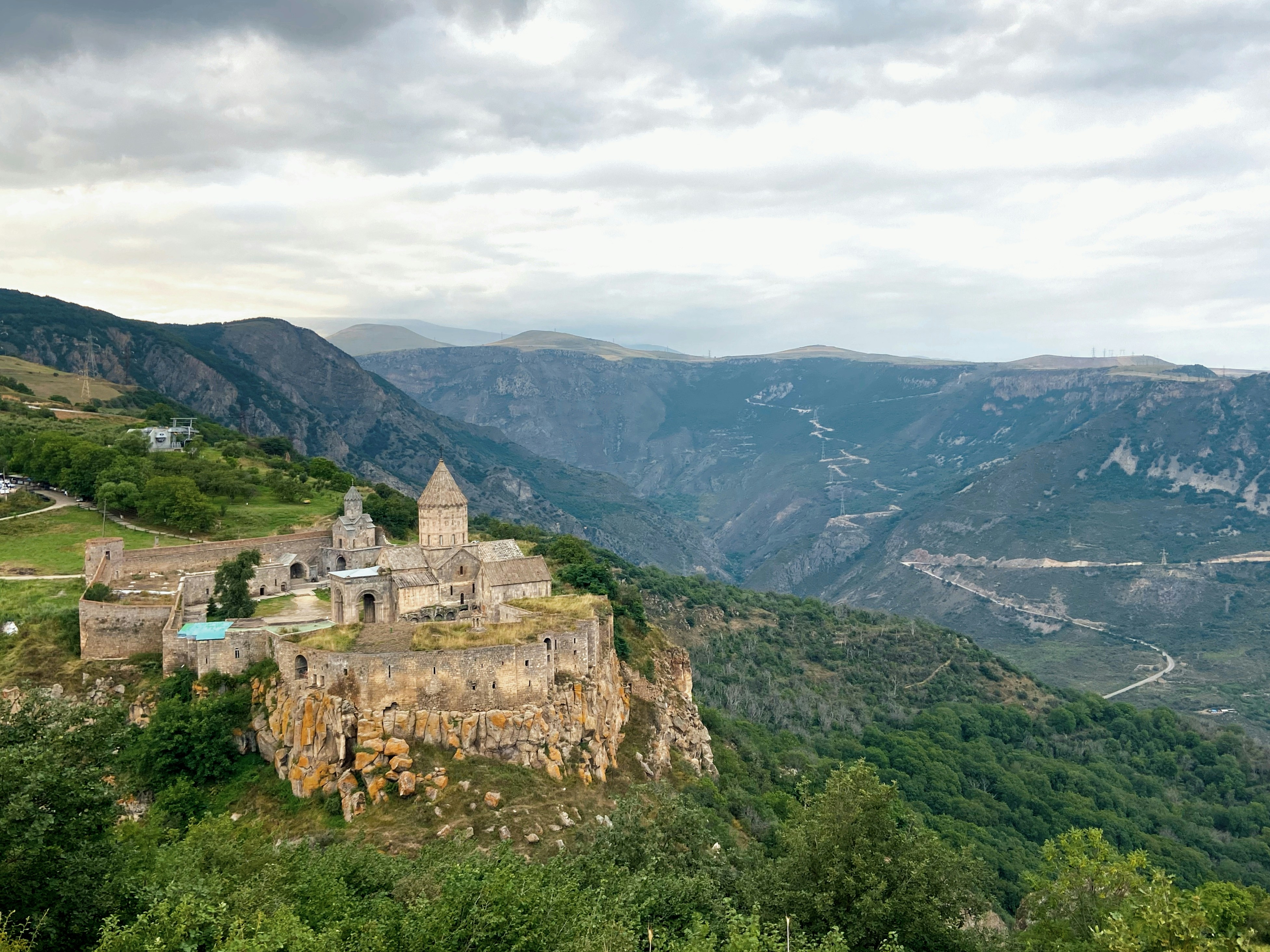 A castle on top of a mountain surrounded by trees, Beautiful view of the Tatev Monastery and green mountains landscape in Tatev, Syunik, Armenia