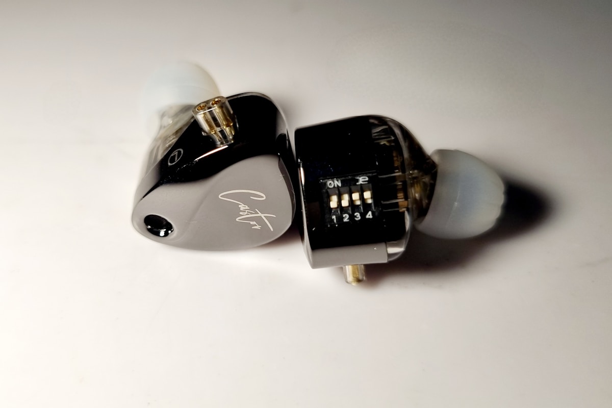 A pair of black and white earbuds on a white surface