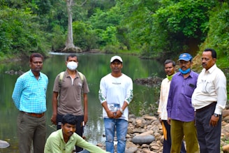 A group of men standing next to each other near a river
