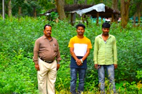 A group of men standing next to each other on a lush green field