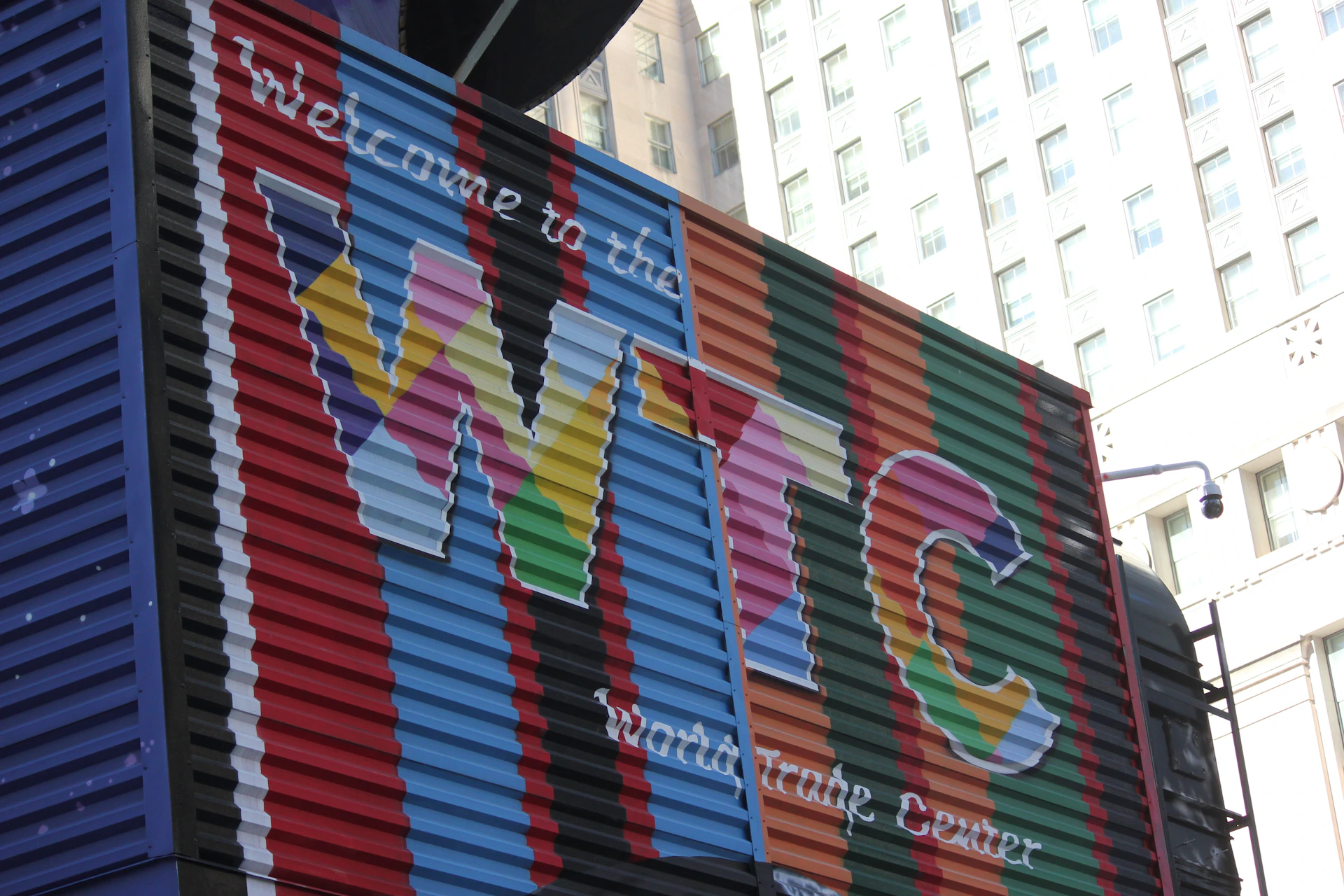 A large colorful container sitting on the side of a building