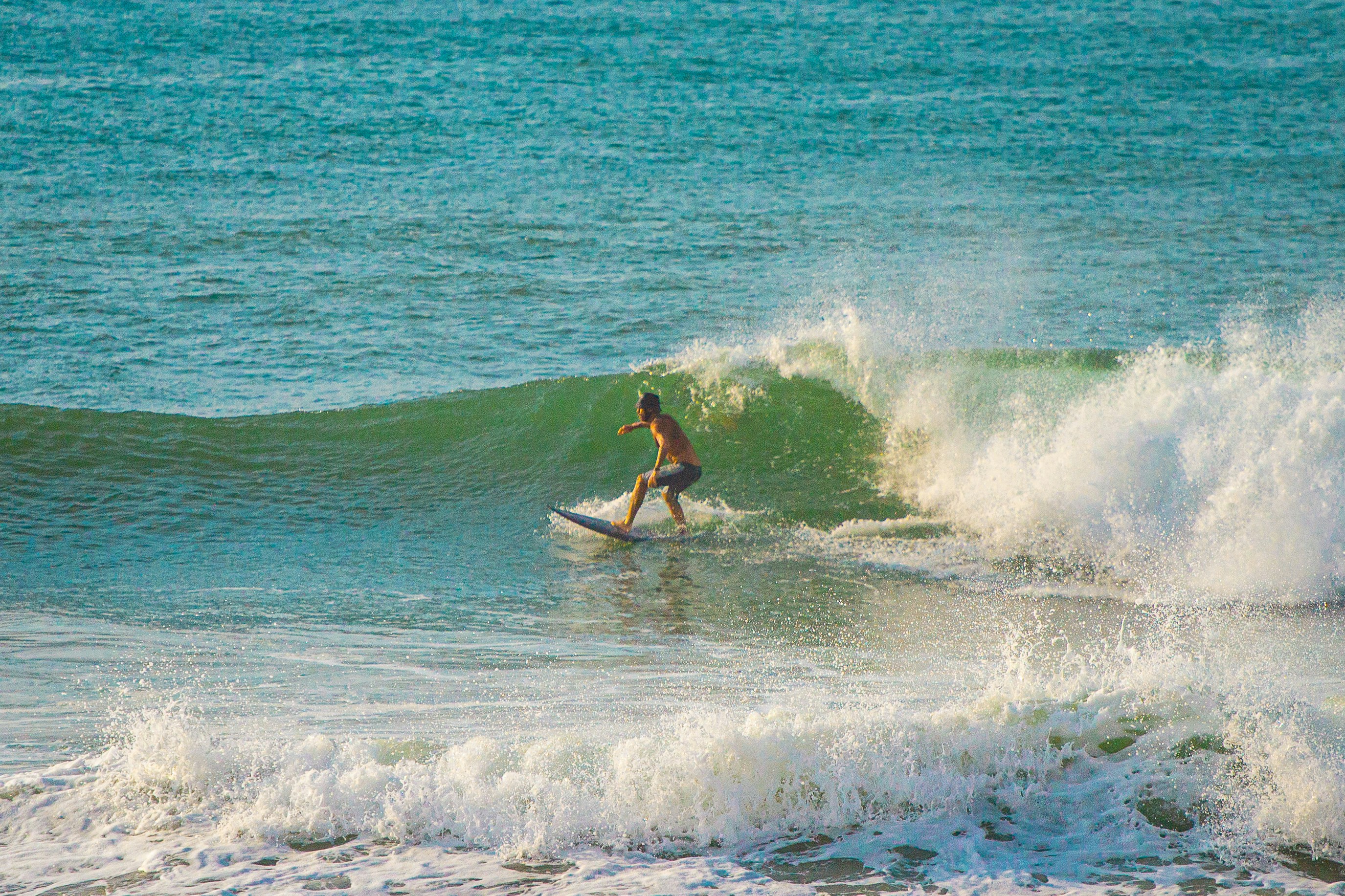 A man riding a wave on top of a surfboard