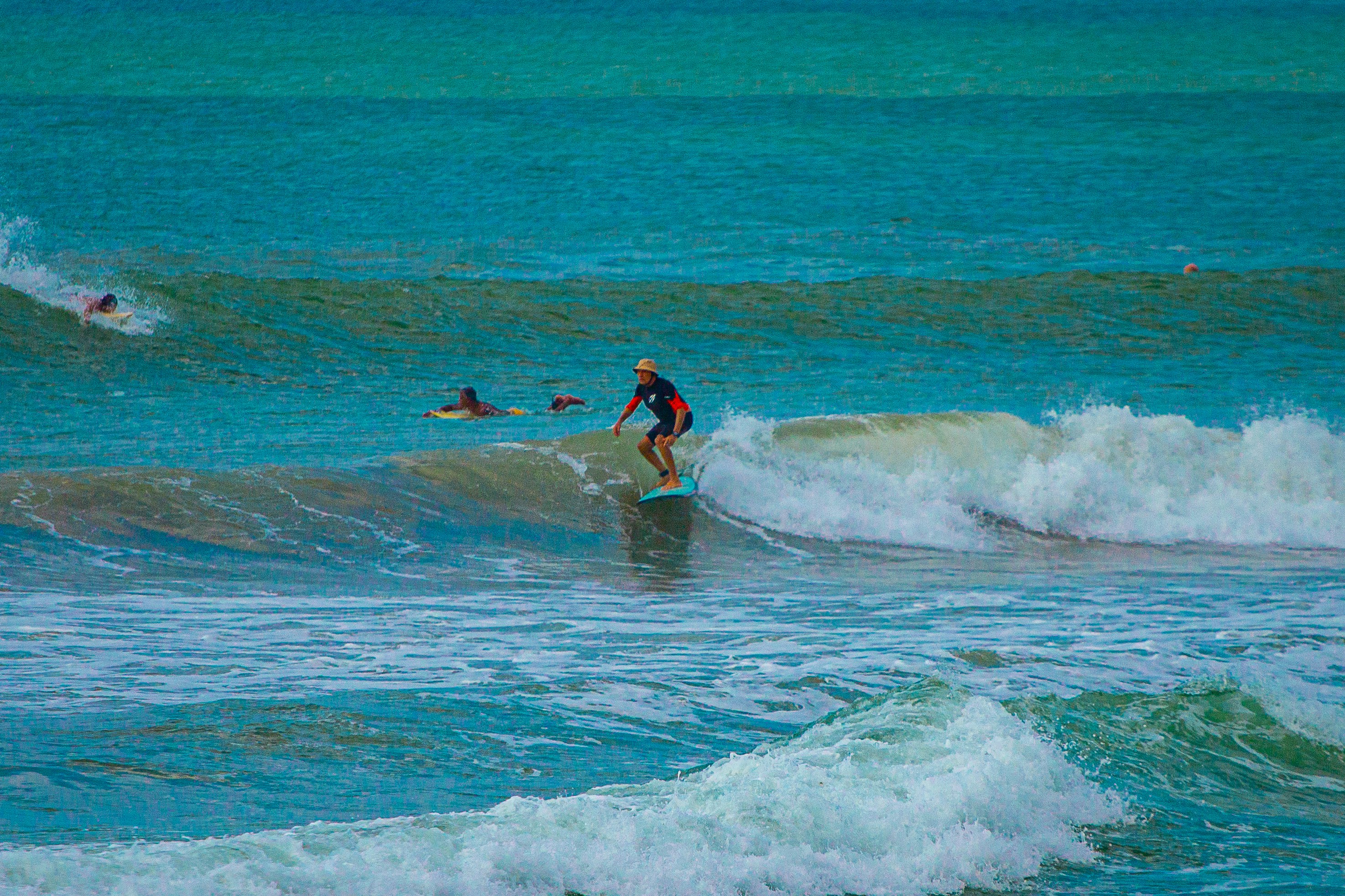 A person riding a wave on top of a surfboard