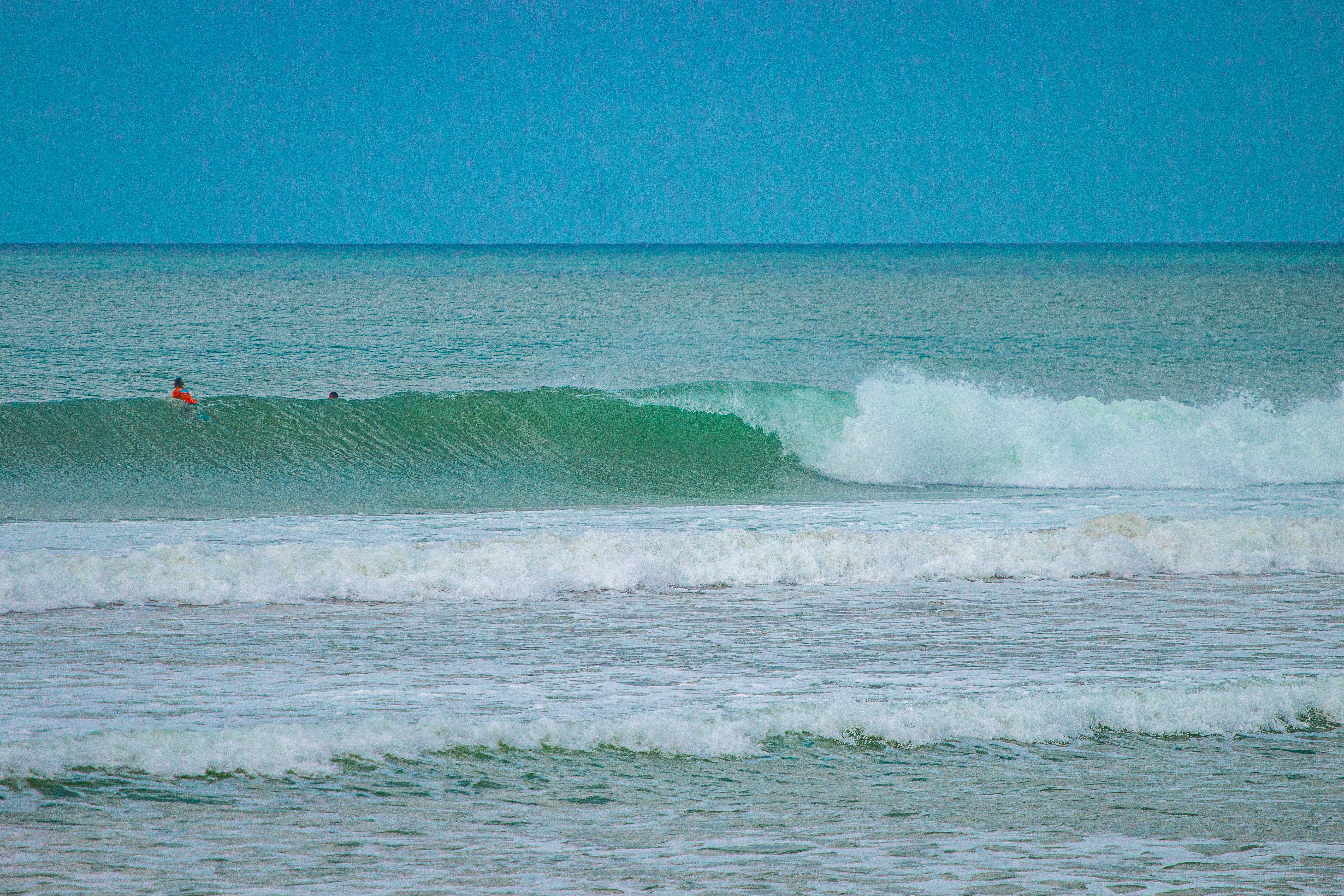 A person riding a surfboard on a wave in the ocean