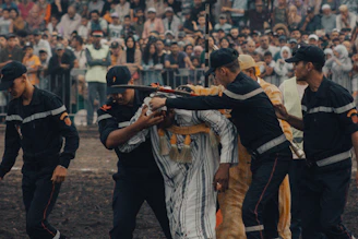 A group of men holding guns in front of a crowd