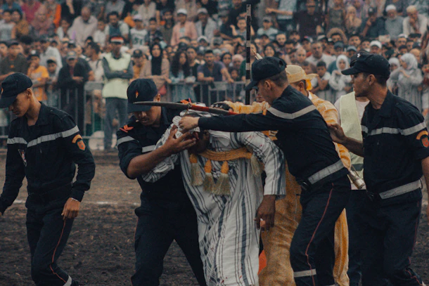 A group of men holding guns in front of a crowd