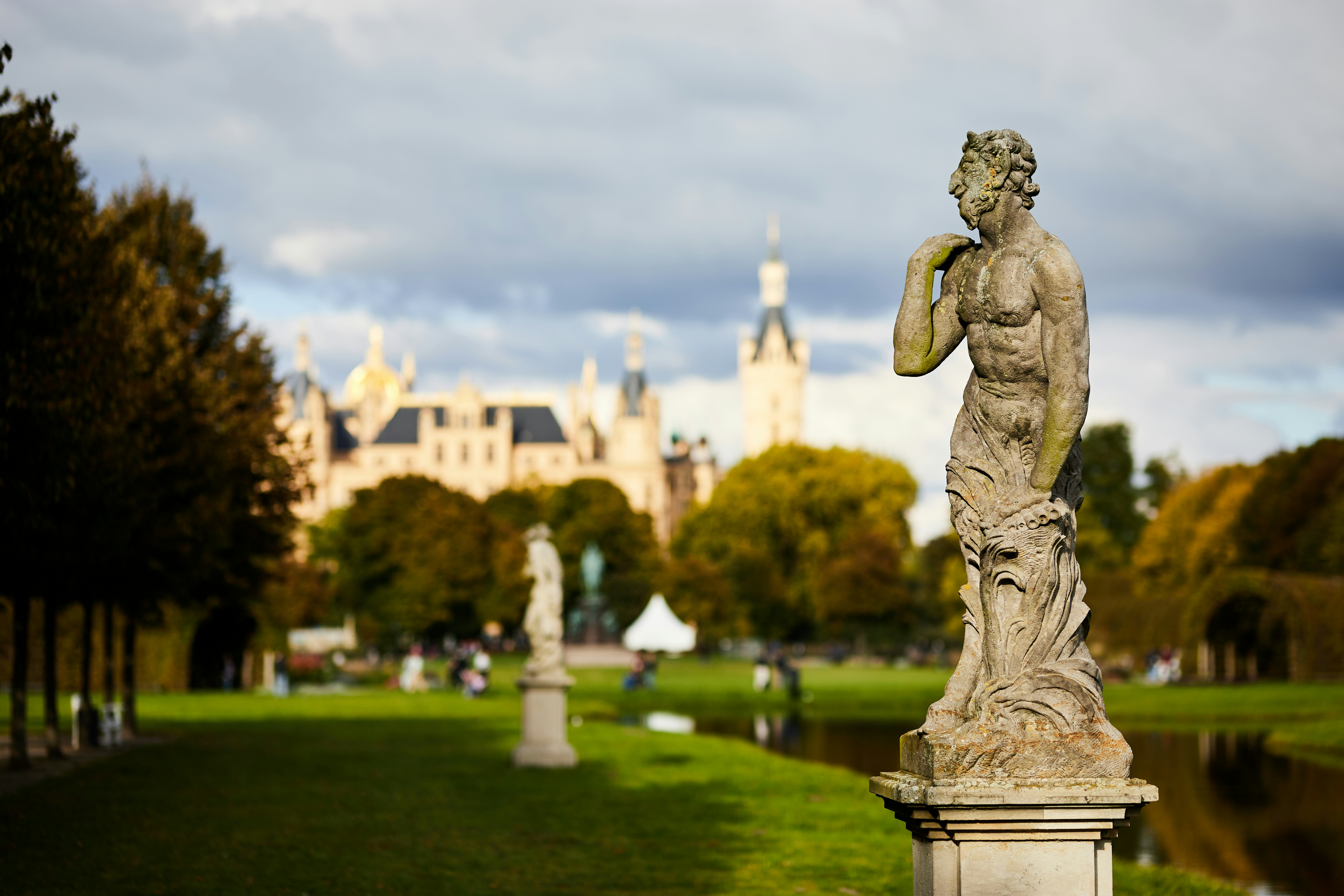 Eine Statue in einem Park mit einer Burg im Hintergrund