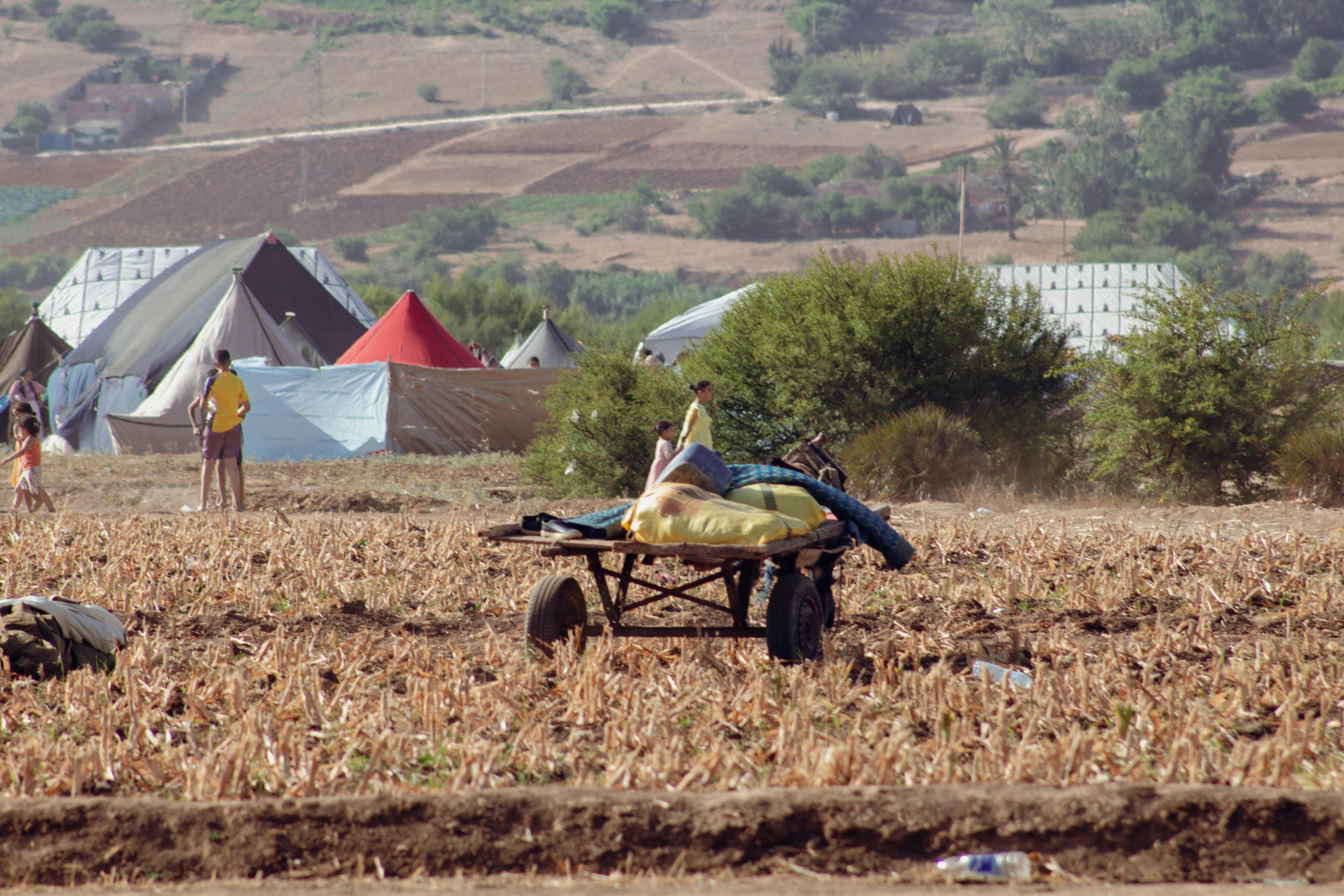 A group of people in a field with tents in the background