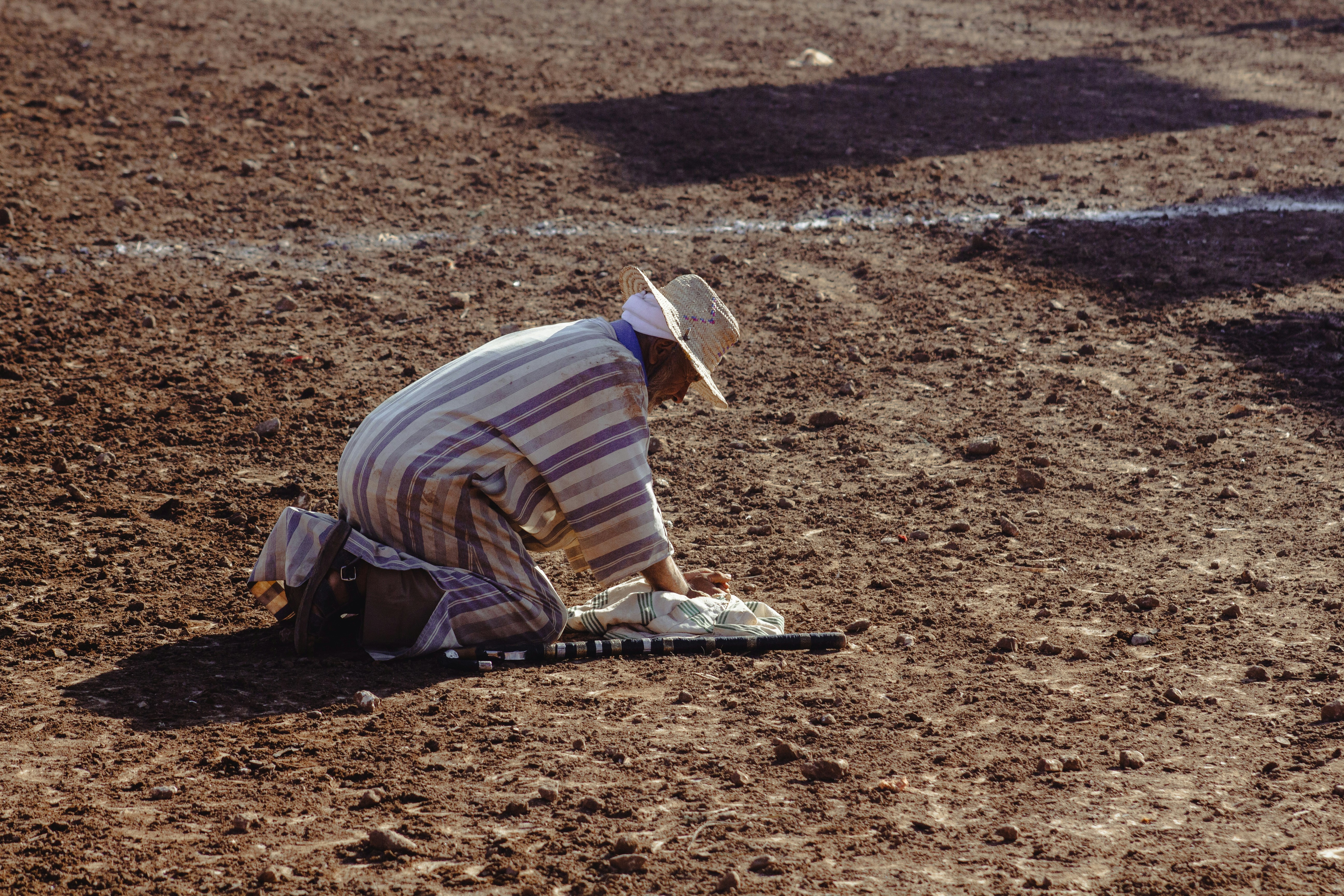 A man sitting on the ground in the middle of a field