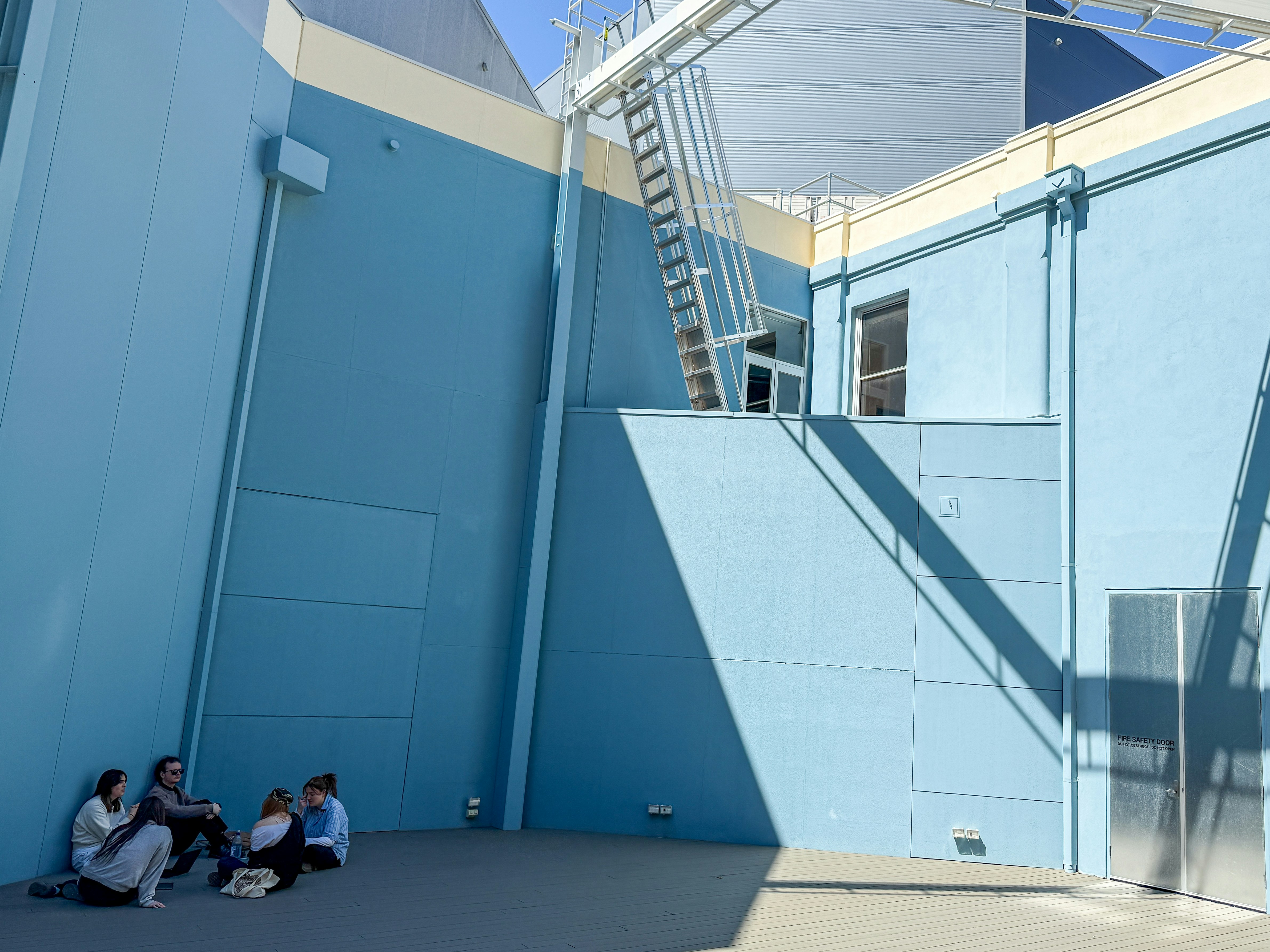 A group of people sitting on the side of a building