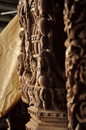 A close up of a wooden sculpture with a cloth in the background