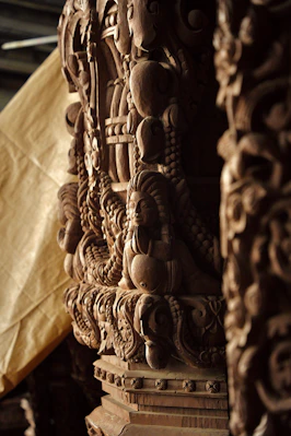 A close up of a wooden sculpture with a cloth in the background