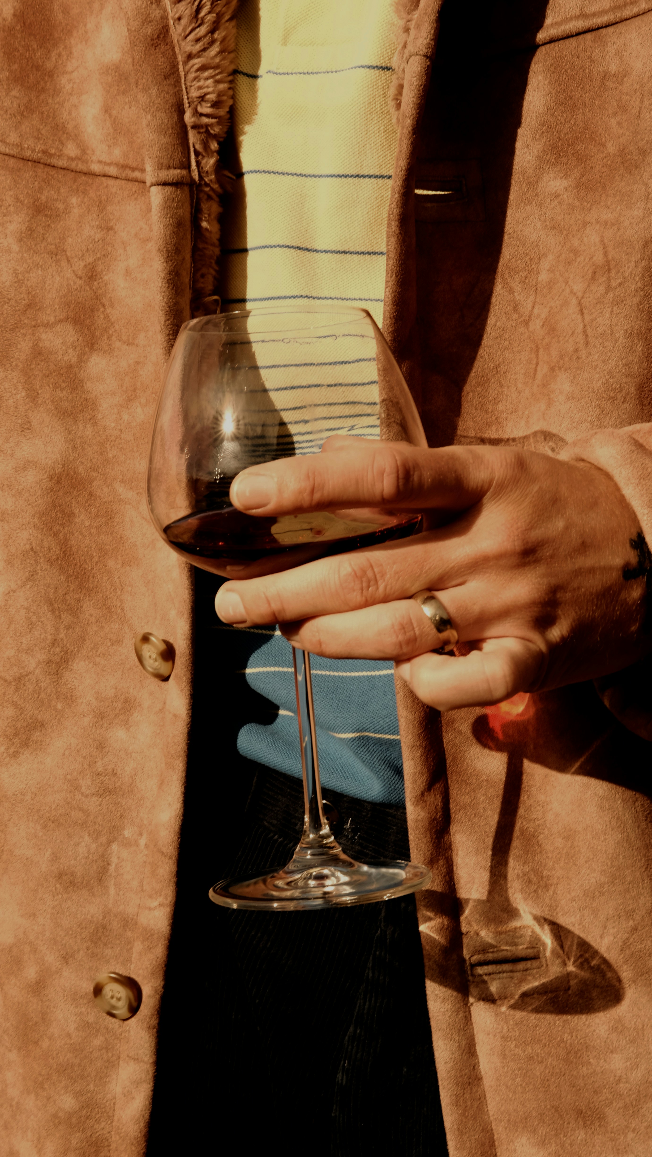 A person holding a wine glass in their hand